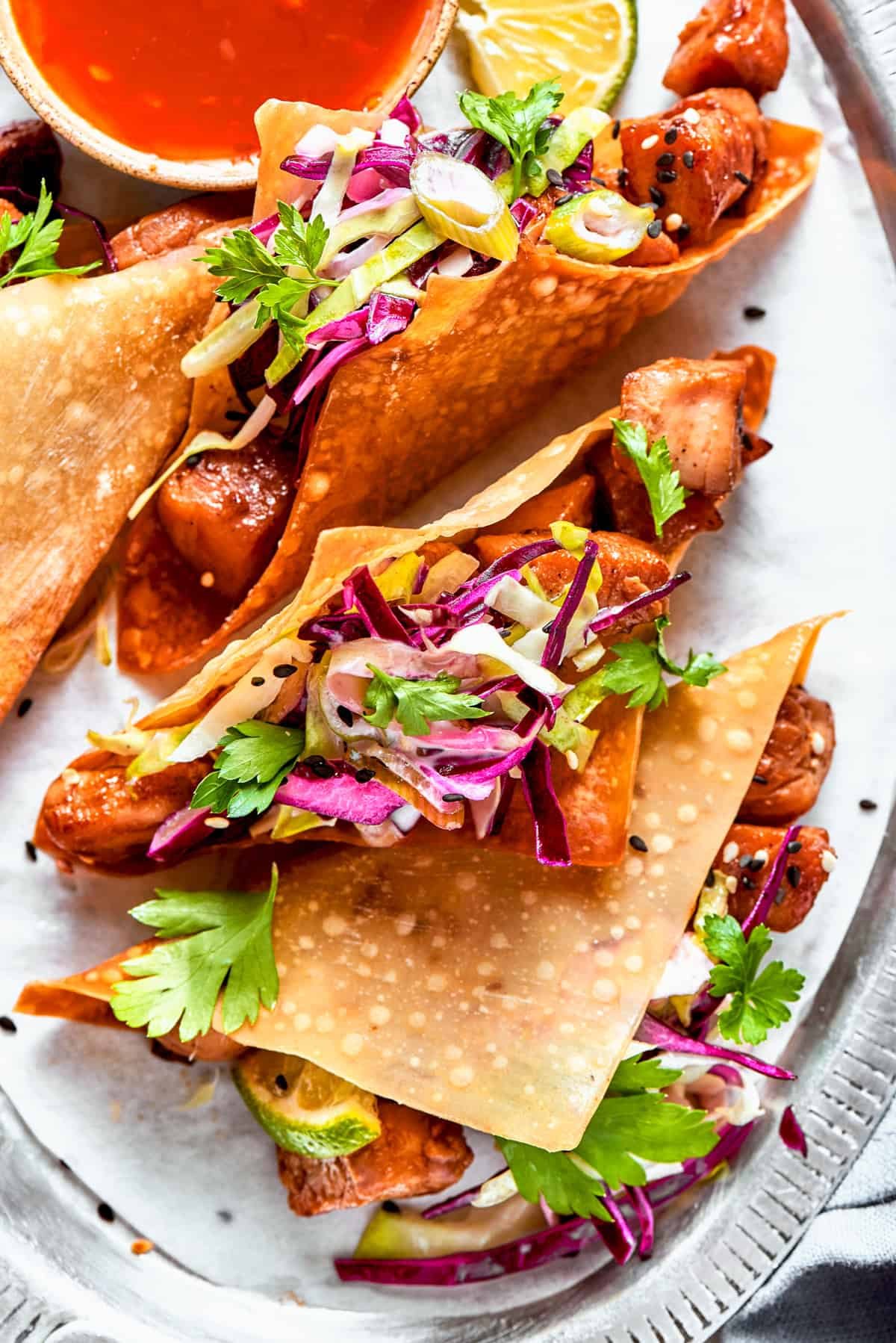Overhead image of wonton tacos stuffed with cooked chicken and coleslaw.