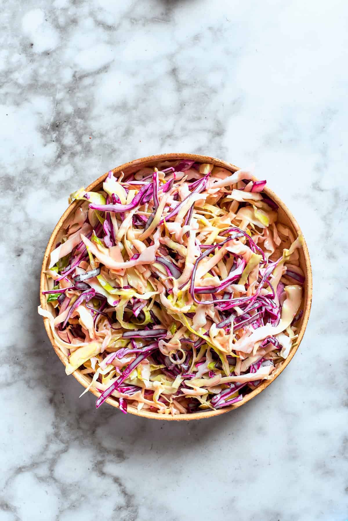 The sauce is combined with the coleslaw mix.
