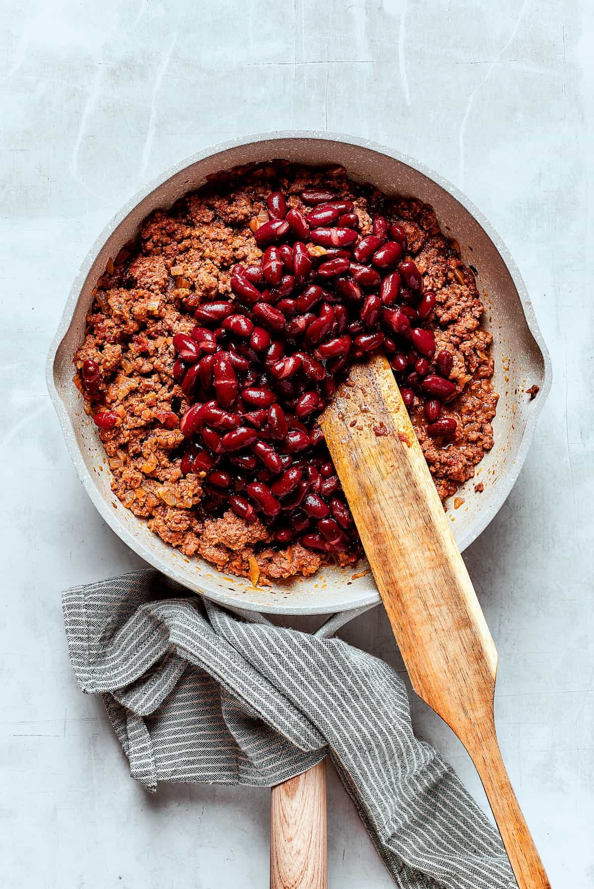 Adding beans to chili.