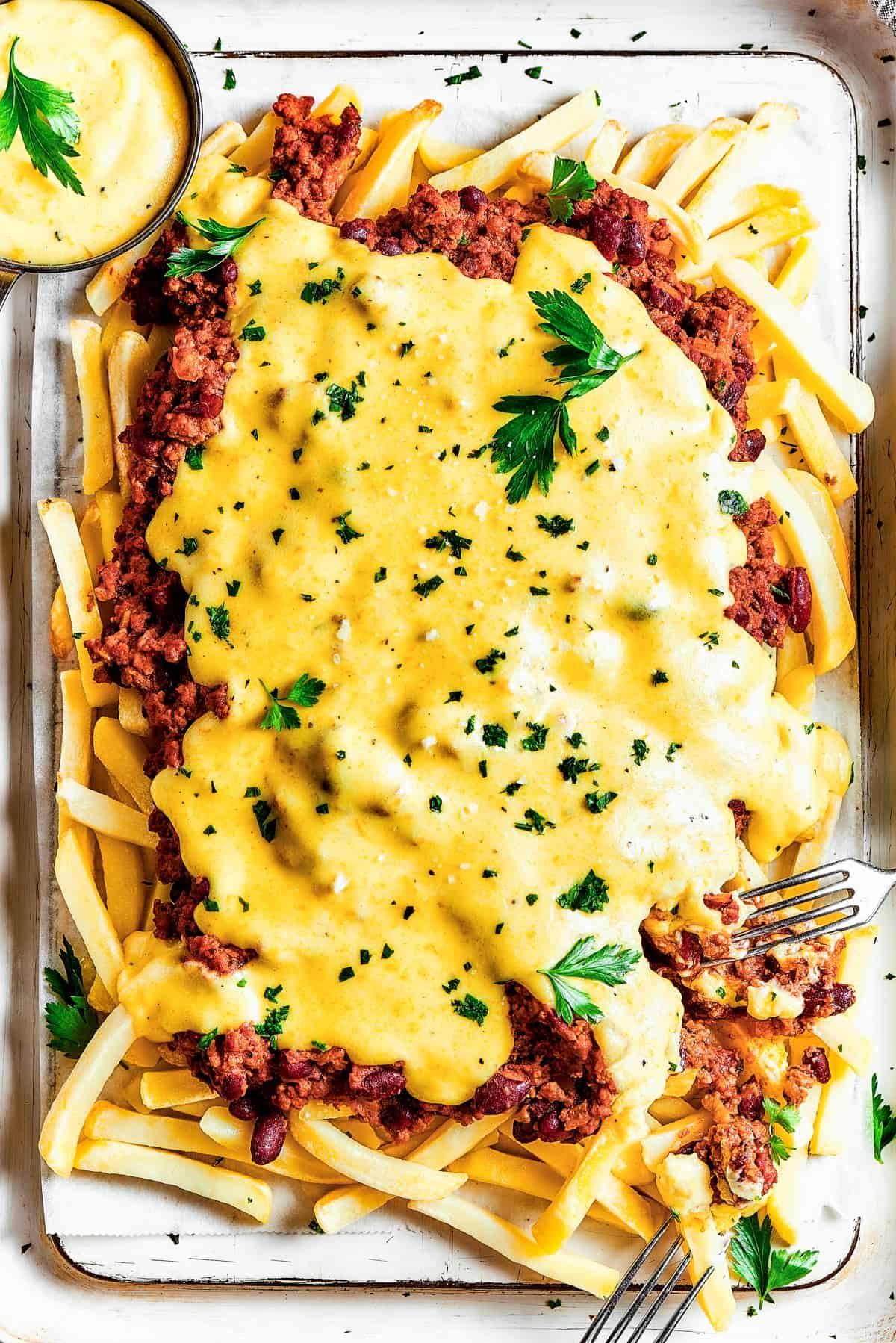 Overhead shot of chili cheese fries with dipping sauce.