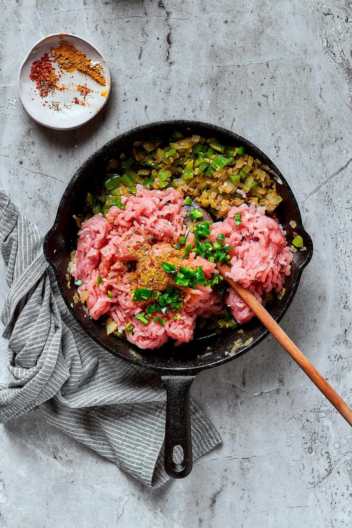 Ground turkey and other ingredients cooking in a skillet.