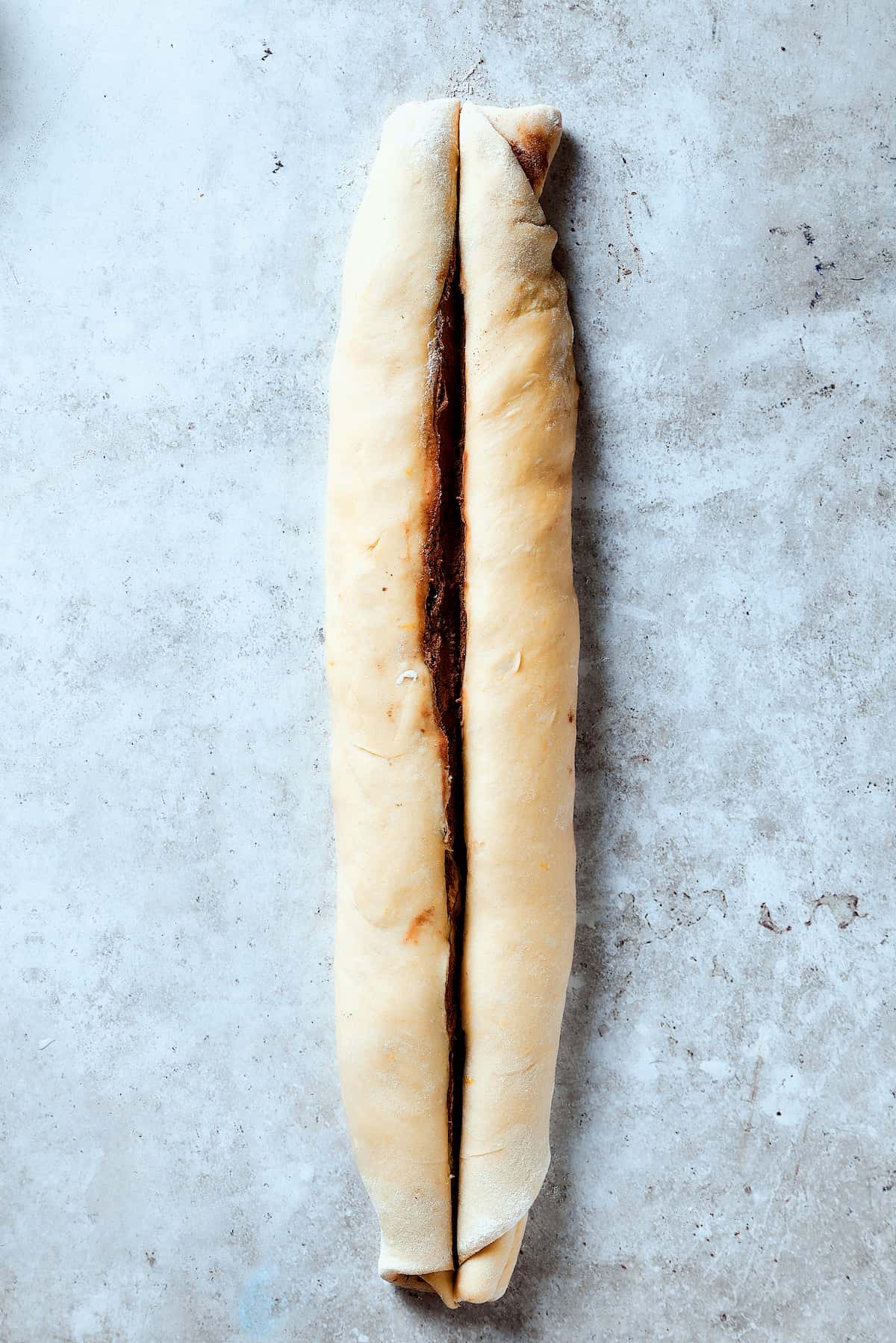 Slicing a roll of dough lengthwise.