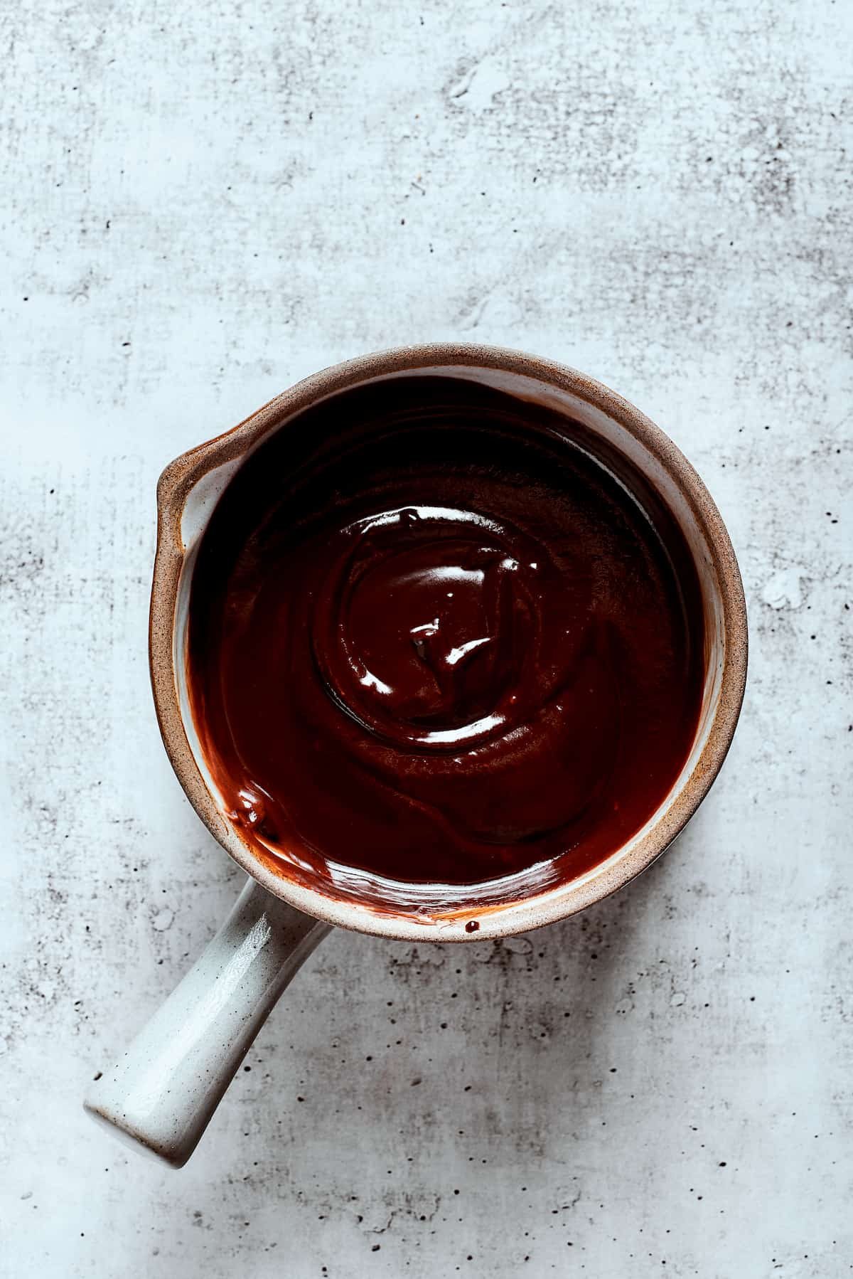 Overhead view of a saucepan full of chocolate ganache.