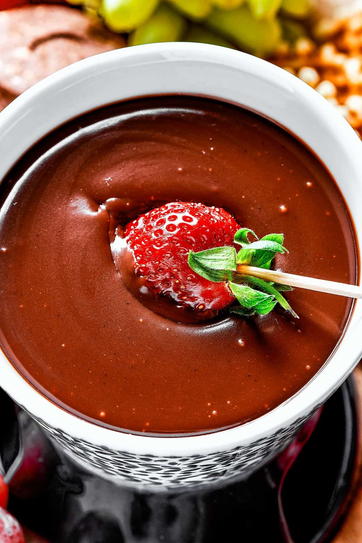 Dipping a strawberry in chocolate fondue.