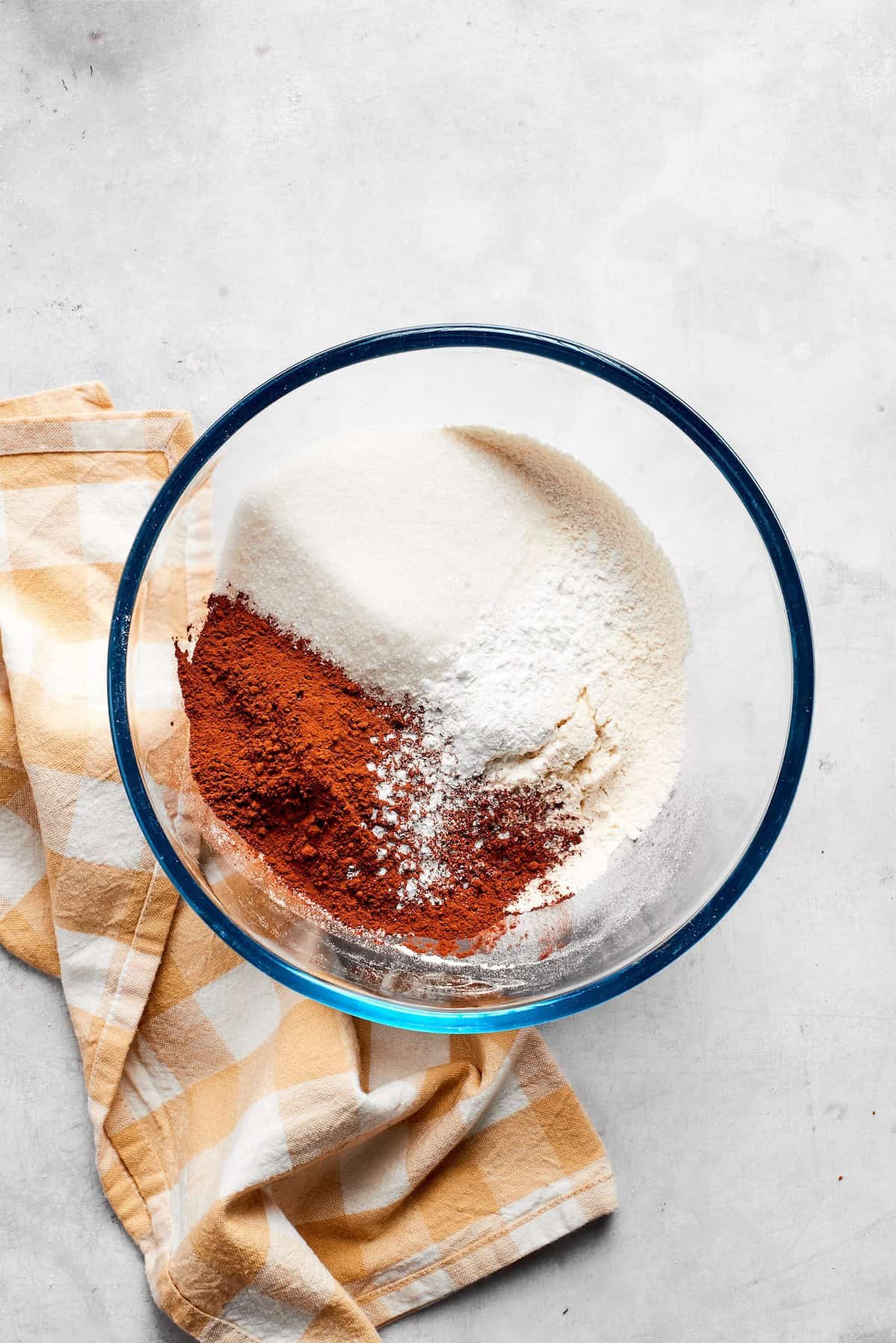 Dry ingredients for chocolate muffins are mixed in a bowl.
