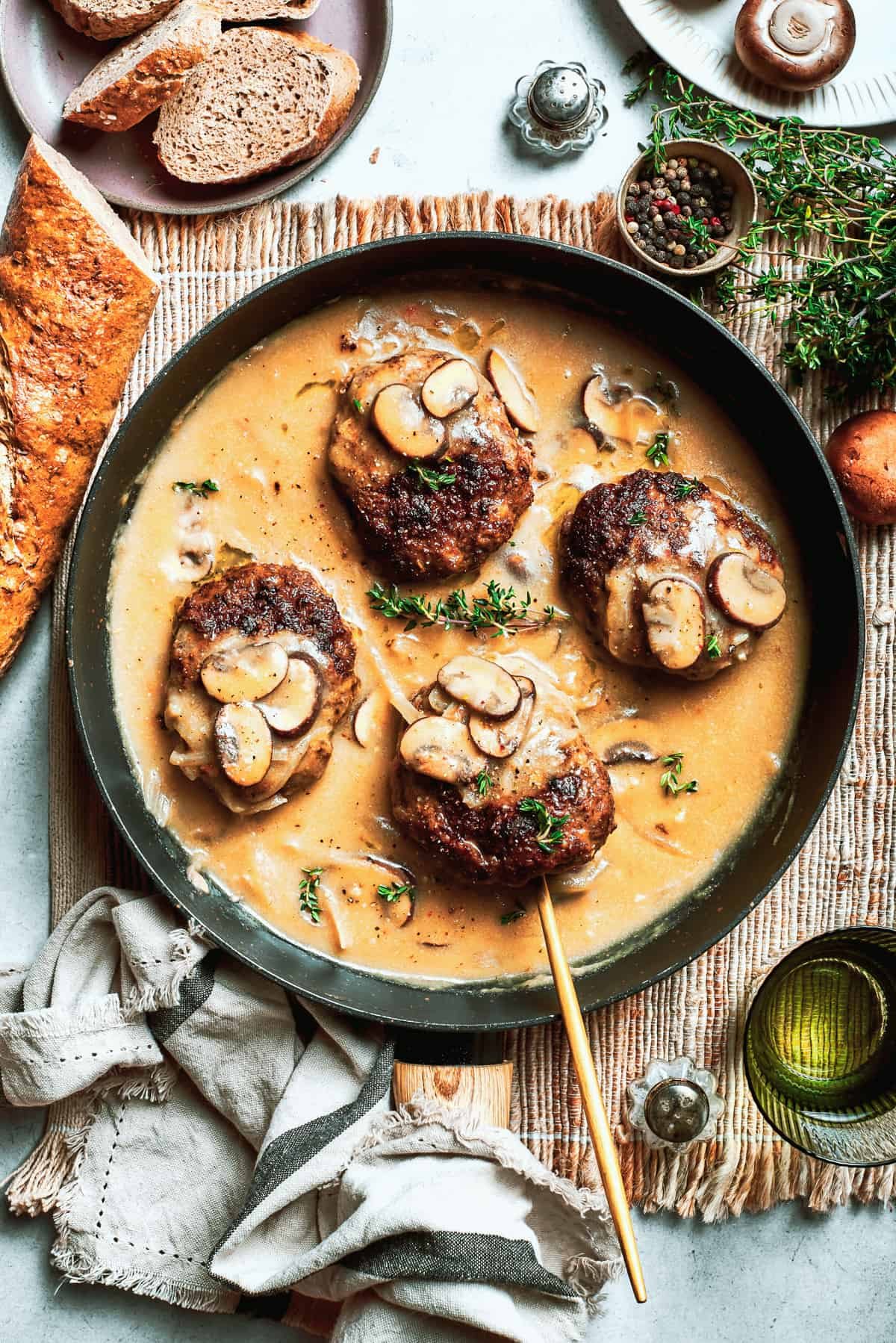 Four pieces of chopped steak are added to a pan with gravy.