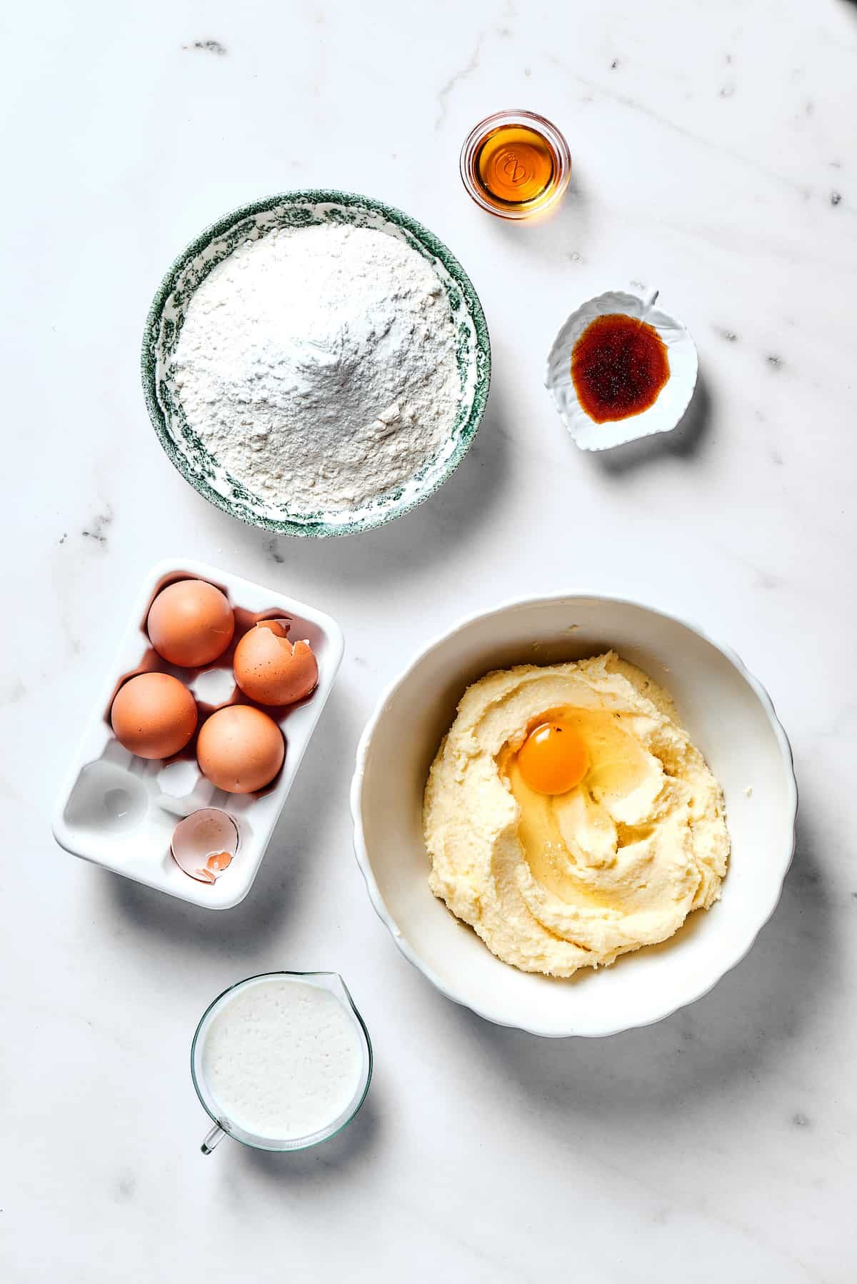 Adding one egg at a time to the mixing bowl.