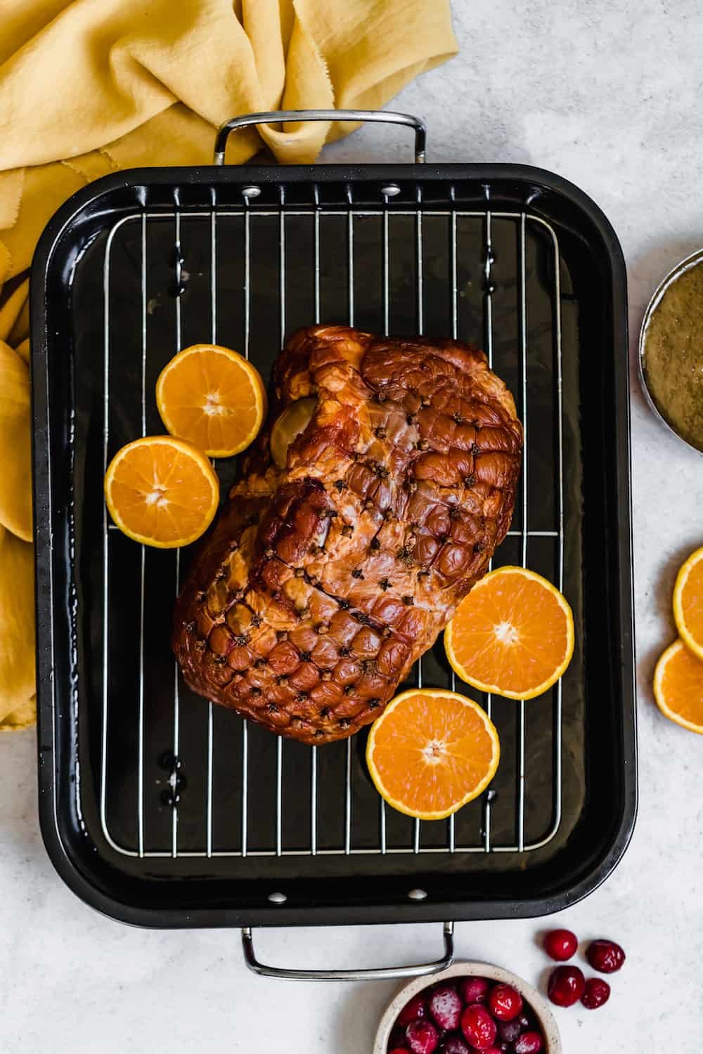 A Christmas Ham on a Roasting Pan with Four Orange Slices