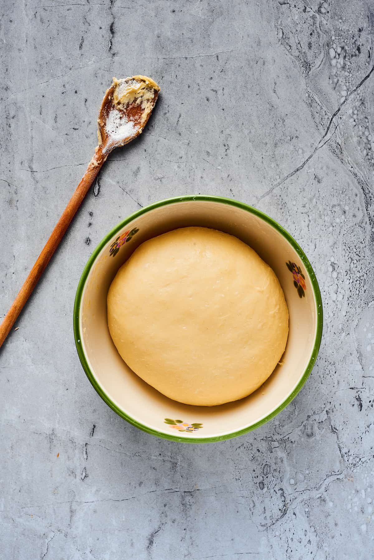 A smooth ball of dough in a large ceramic bowl.