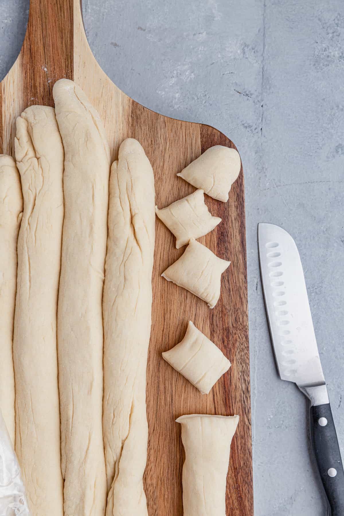 Ropes of pretzel dough being cut