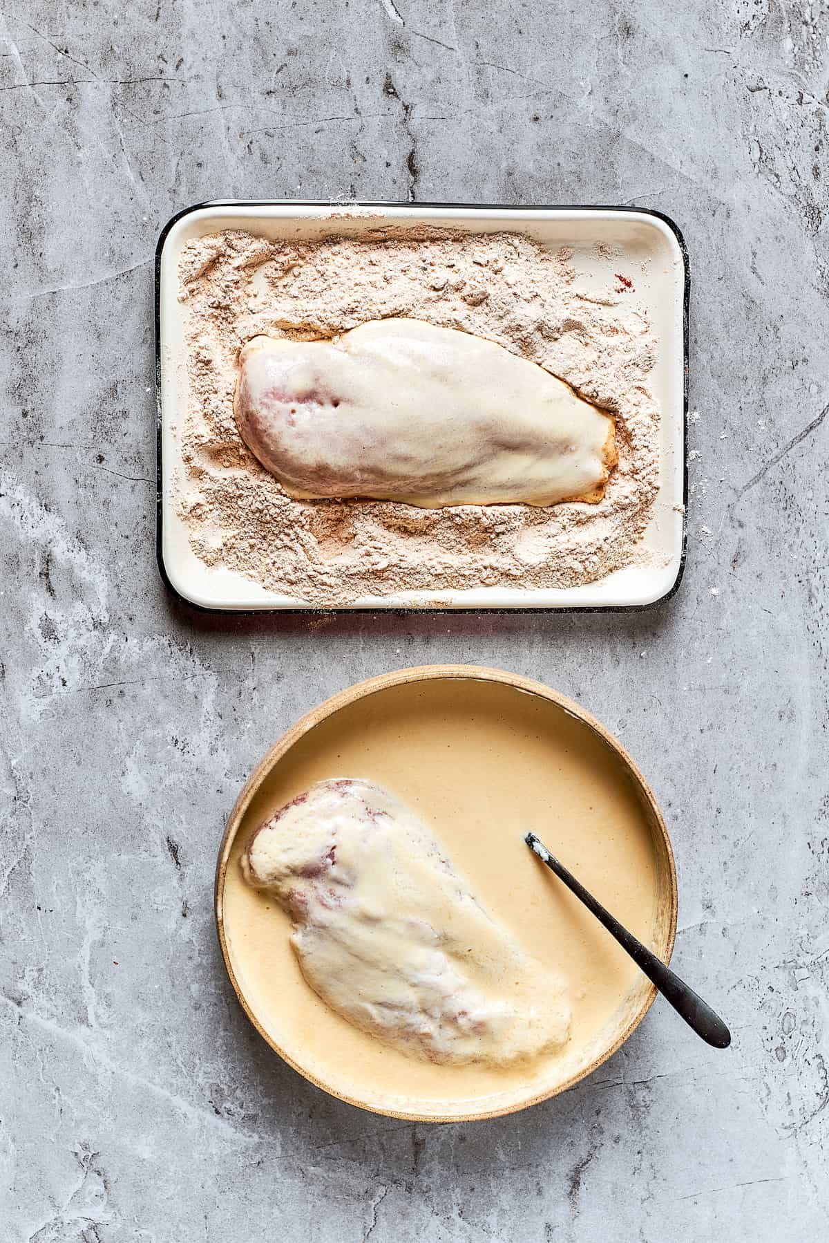 Dredging the chicken in seasoned flour.