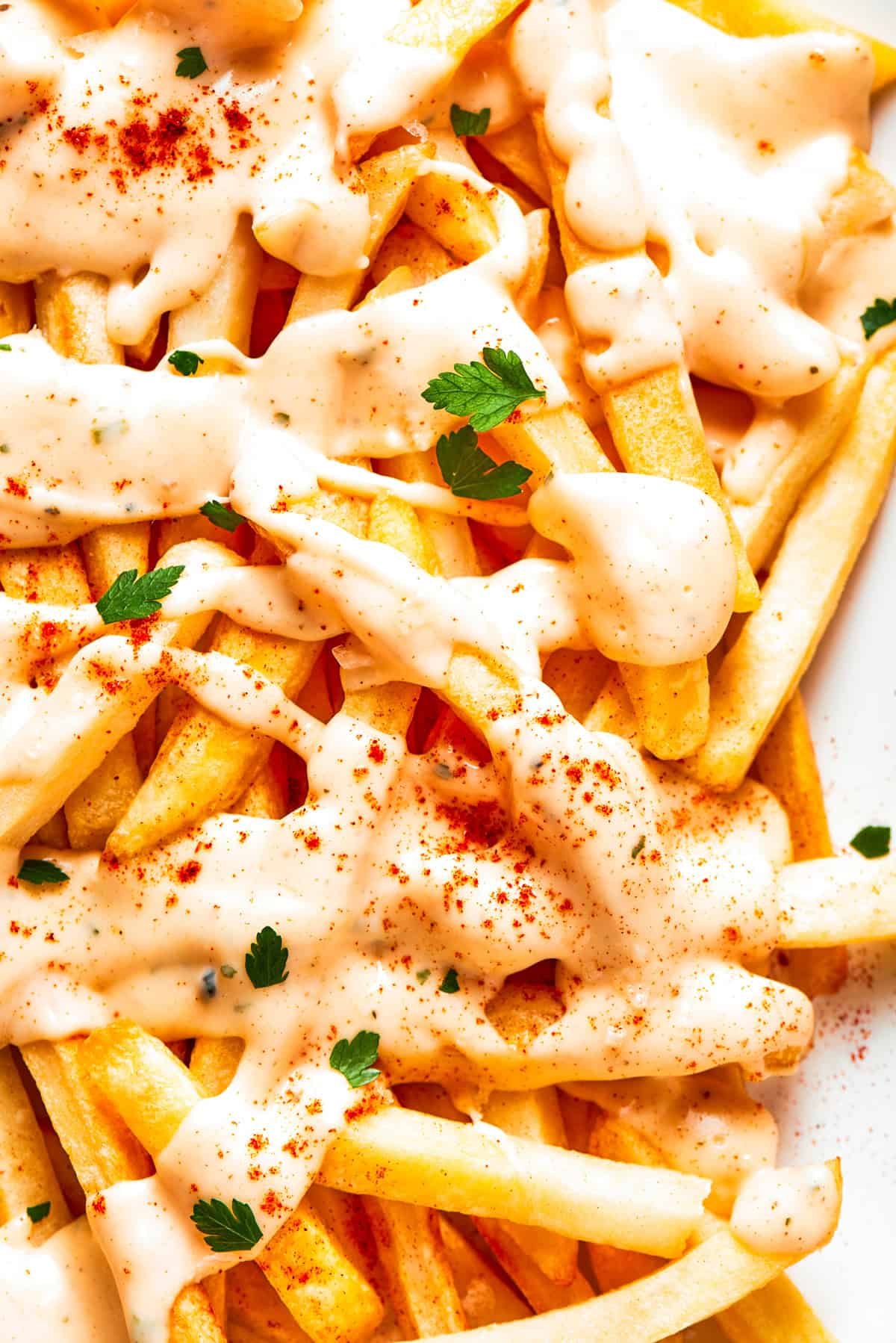 Crispy voodoo fries are drizzled with cheese sauce.