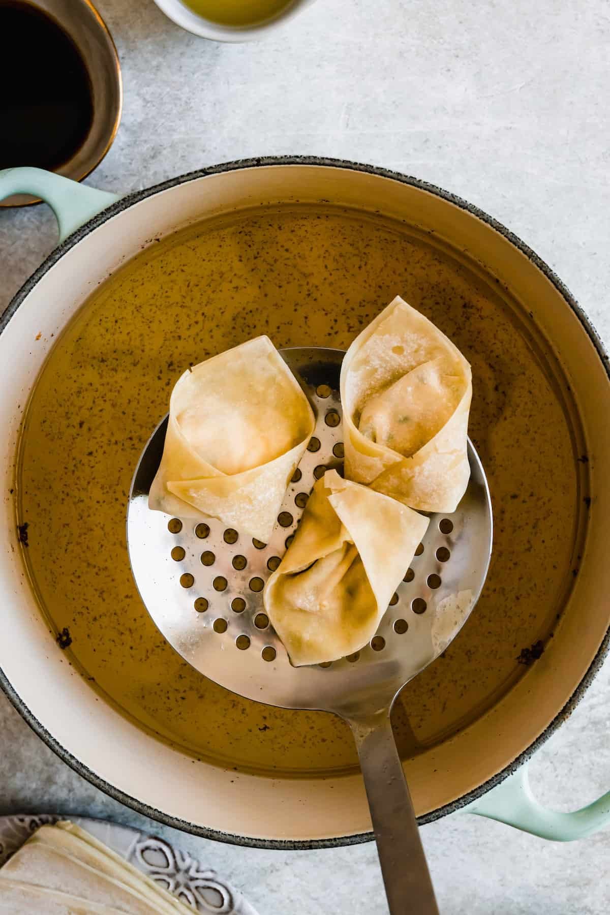 Crab rangoon wontons being fried