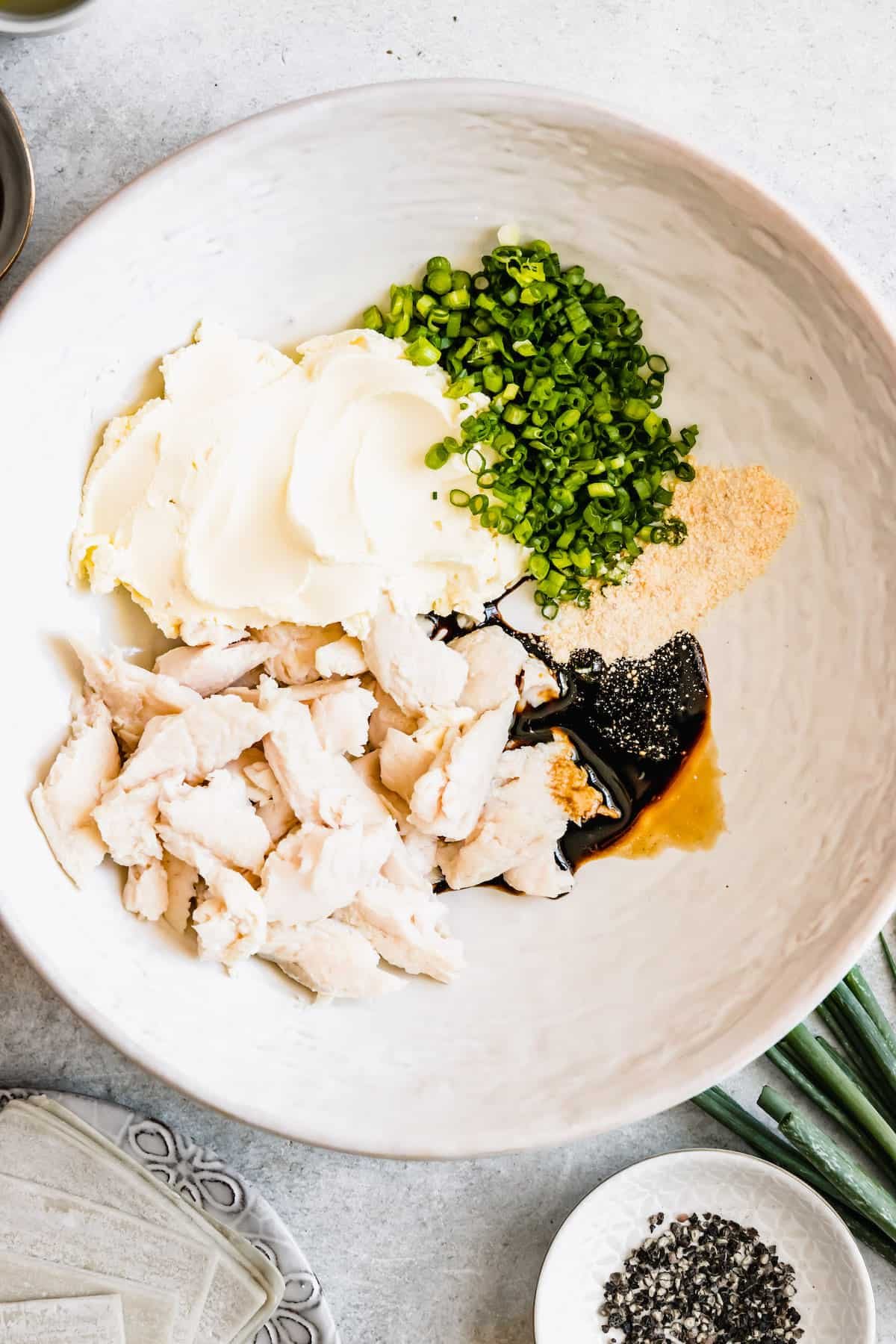 A bowl of crab meat, cream cheese and seasonings.