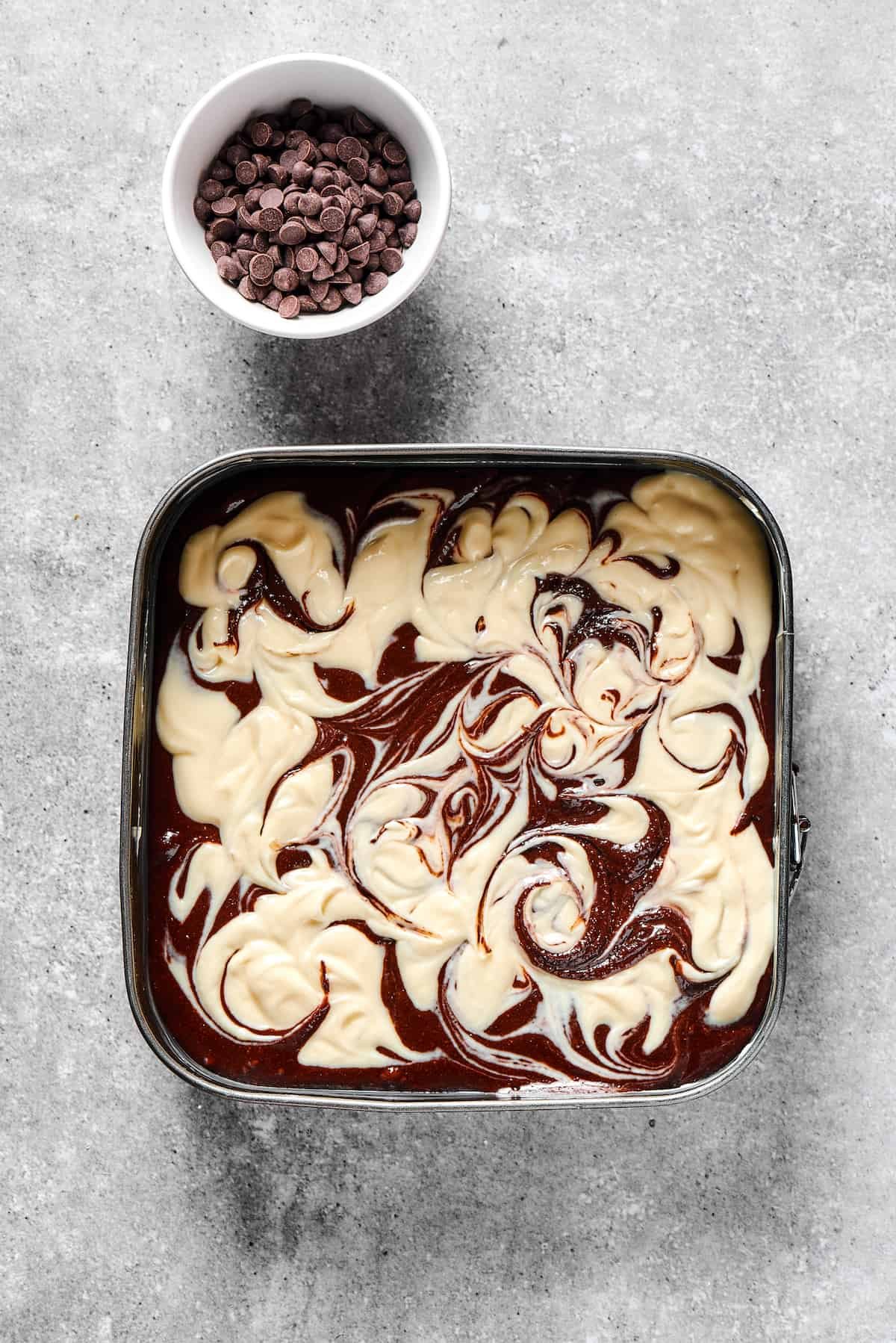 Swirled, unbaked cream cheese brownies.