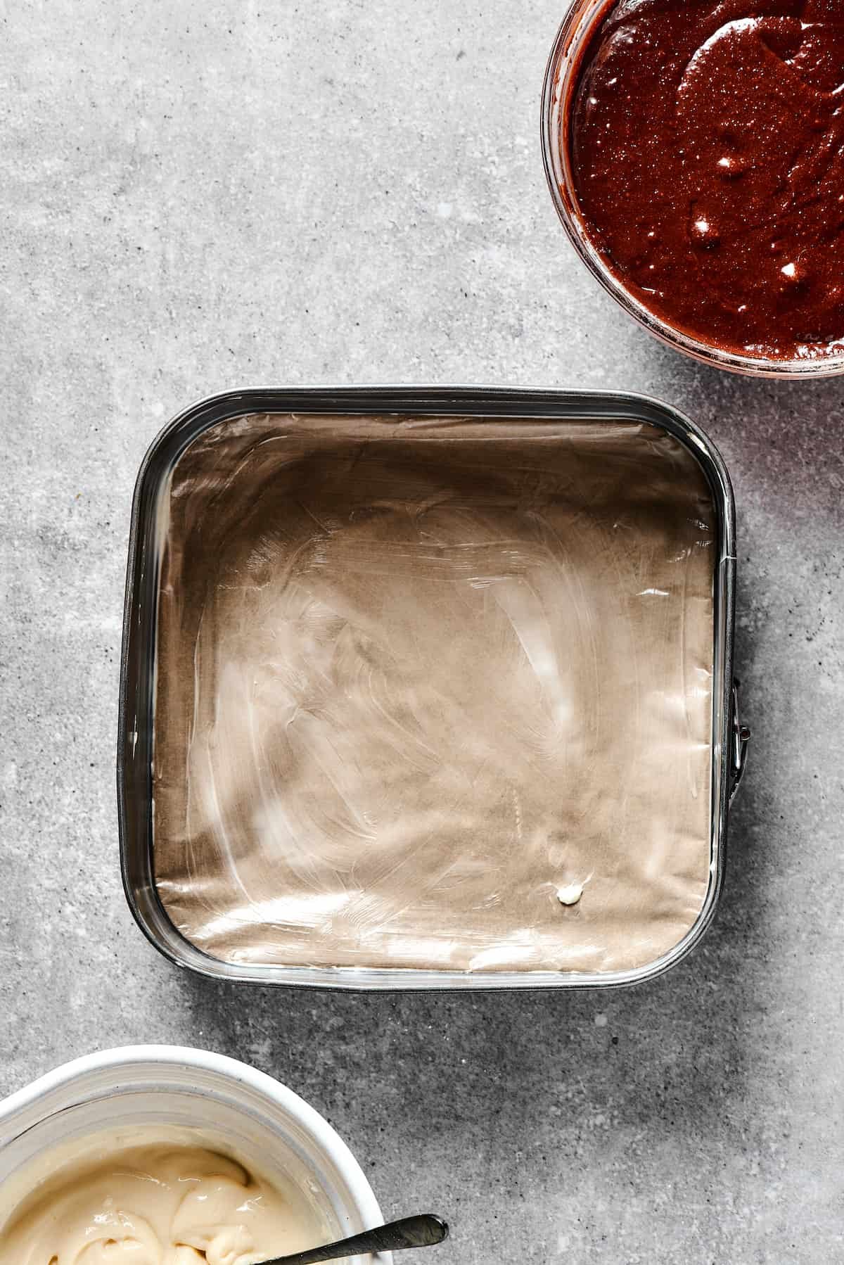 A 9x9 baking dish lined with parchment.