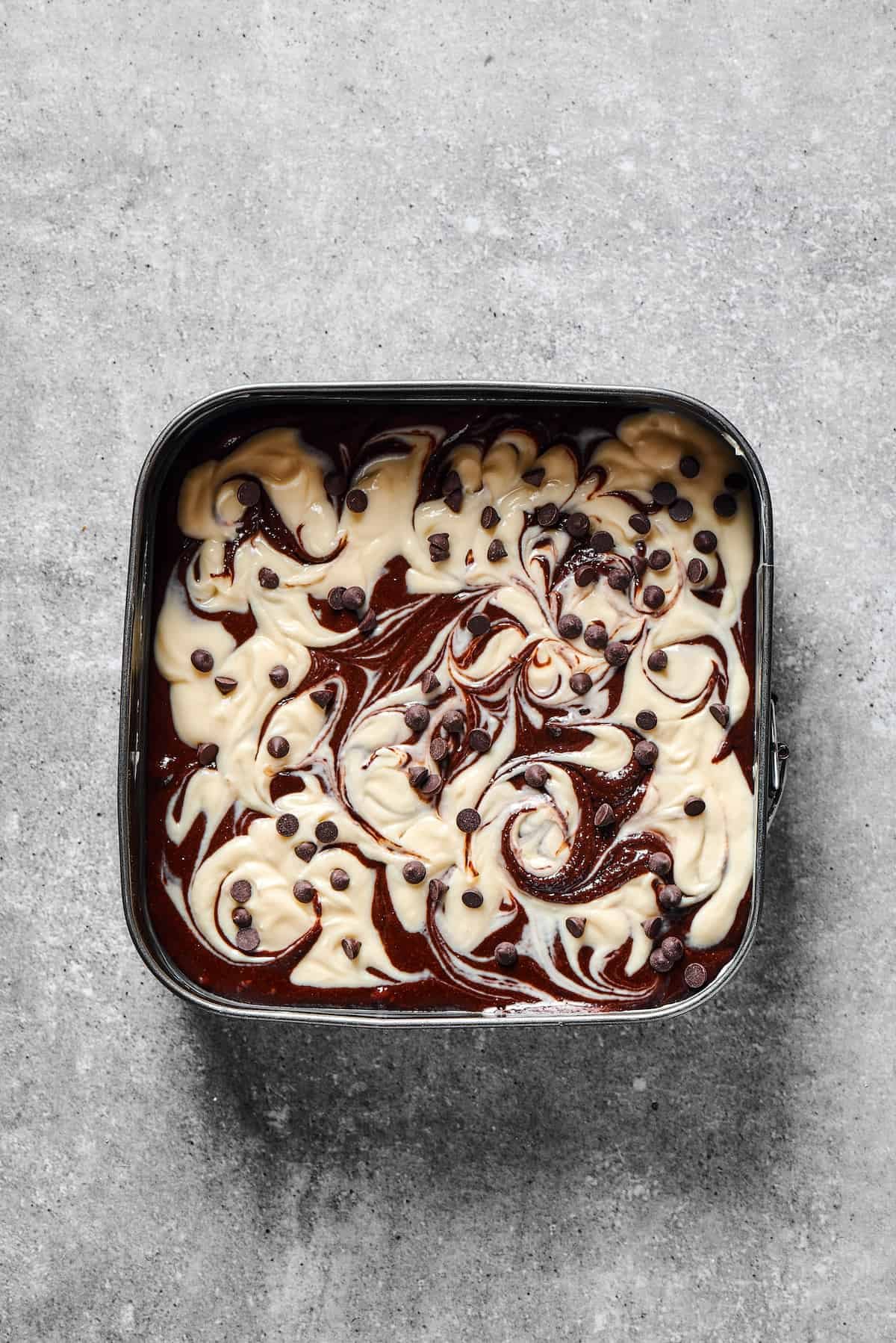 Cheesecake brownies topped with chocolate chips.