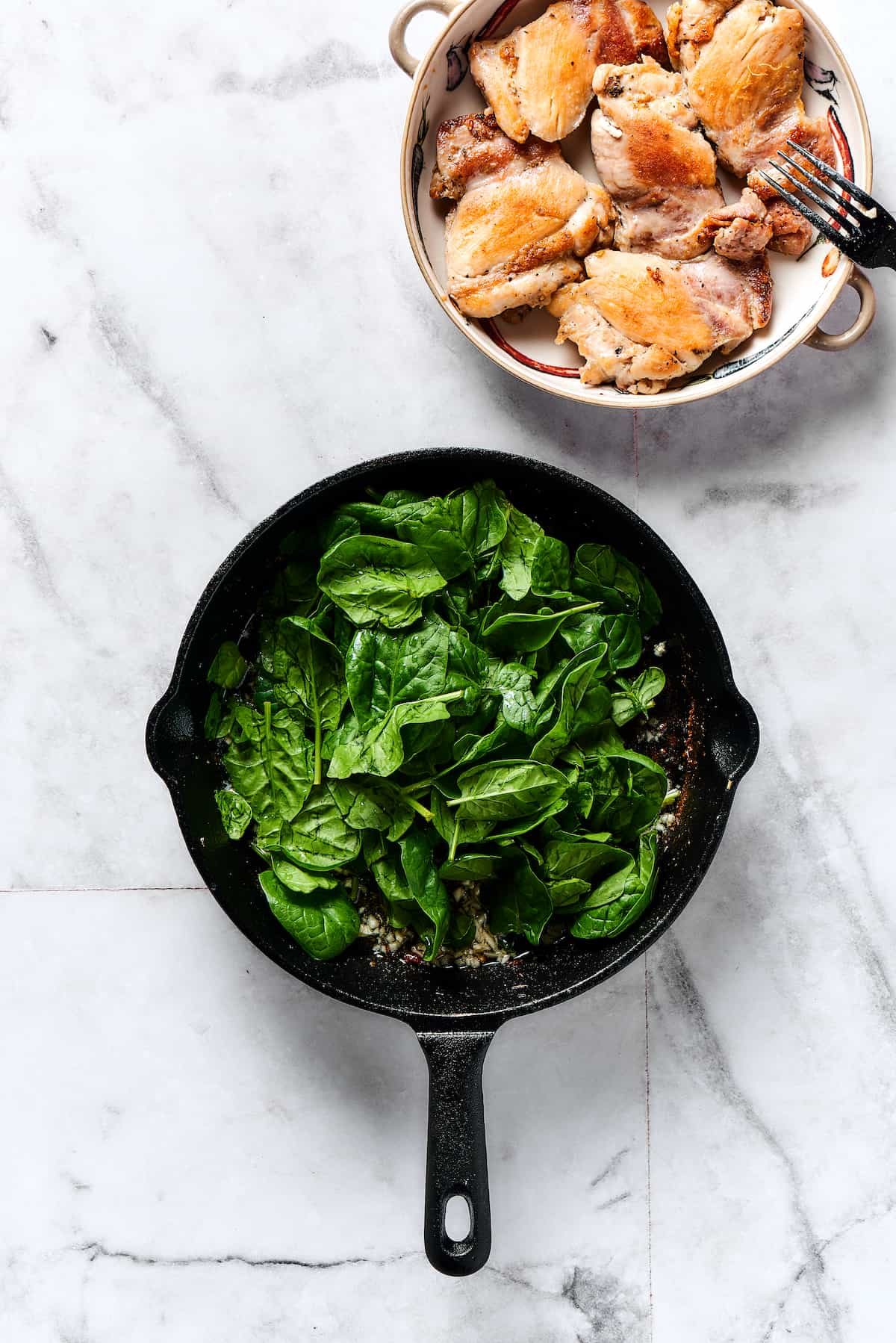 Baby spinach cooking in a skillet.