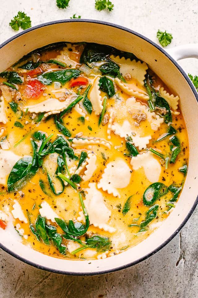 Overhead image of soup with ravioli in a soup pot.
