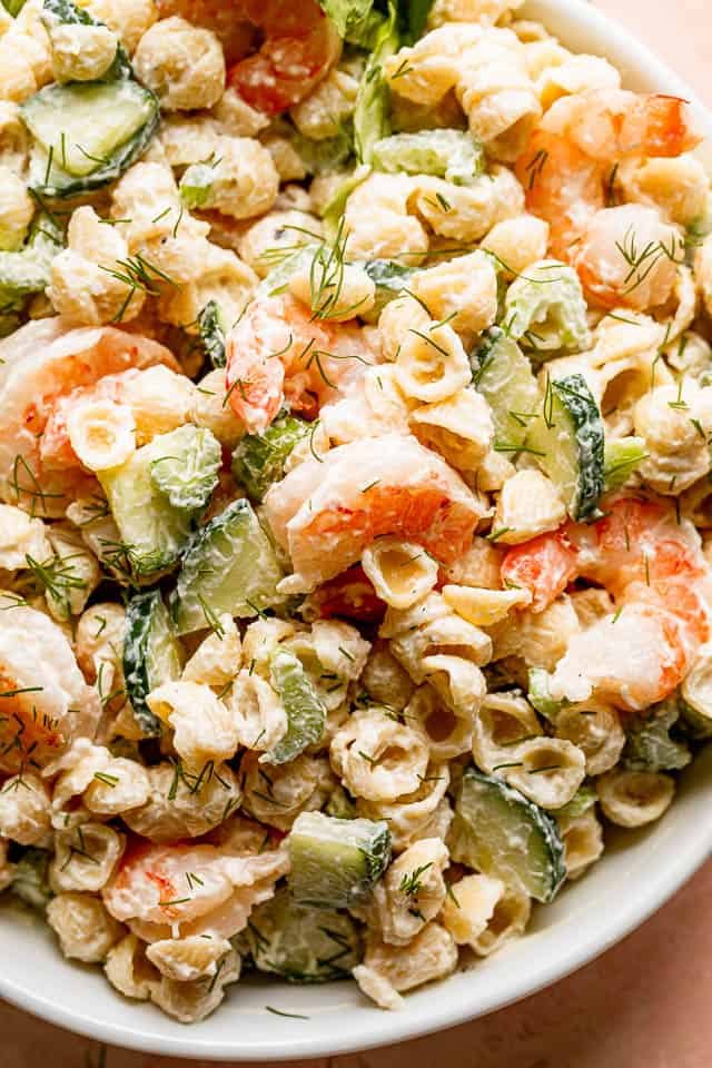 close up shot of Creamy Shrimp Pasta Salad studded with sliced cucumbers and plump shrimp