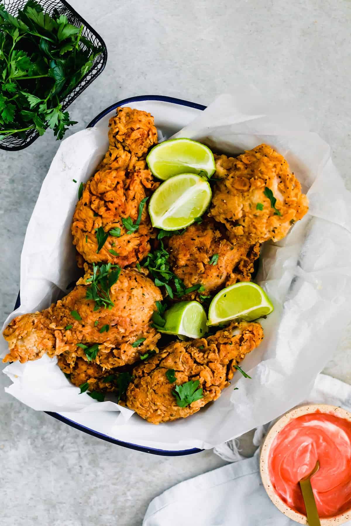 A Bowl of Buttermilk Fried Chicken Next to a Container of Fresh Parsley
