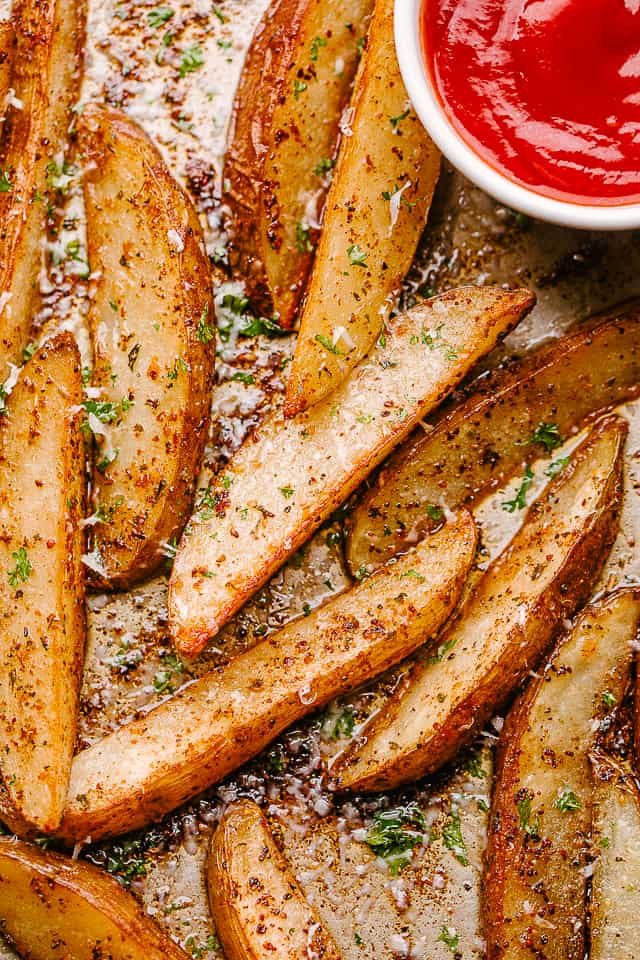 Baked potato wedges on a baking sheet.