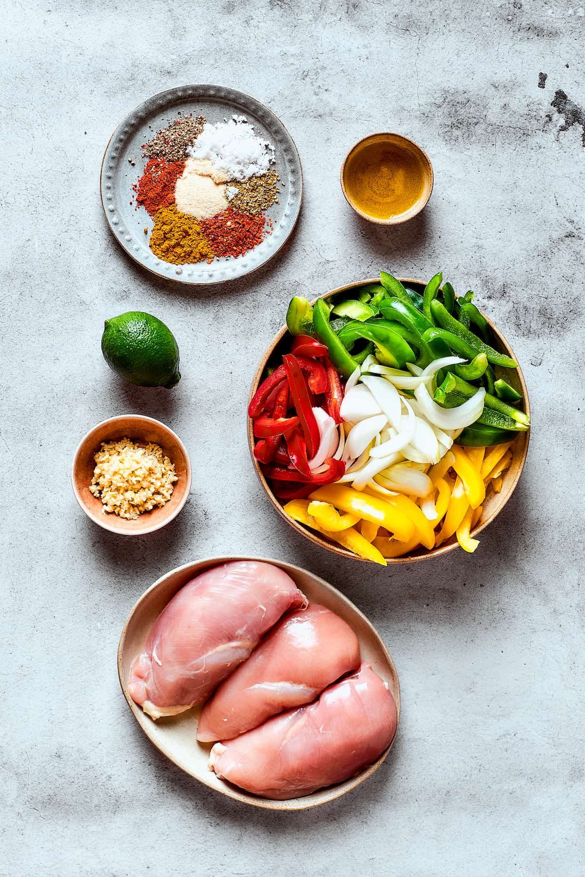 Ingredients for crockpot fajitas arranged on a work surface.