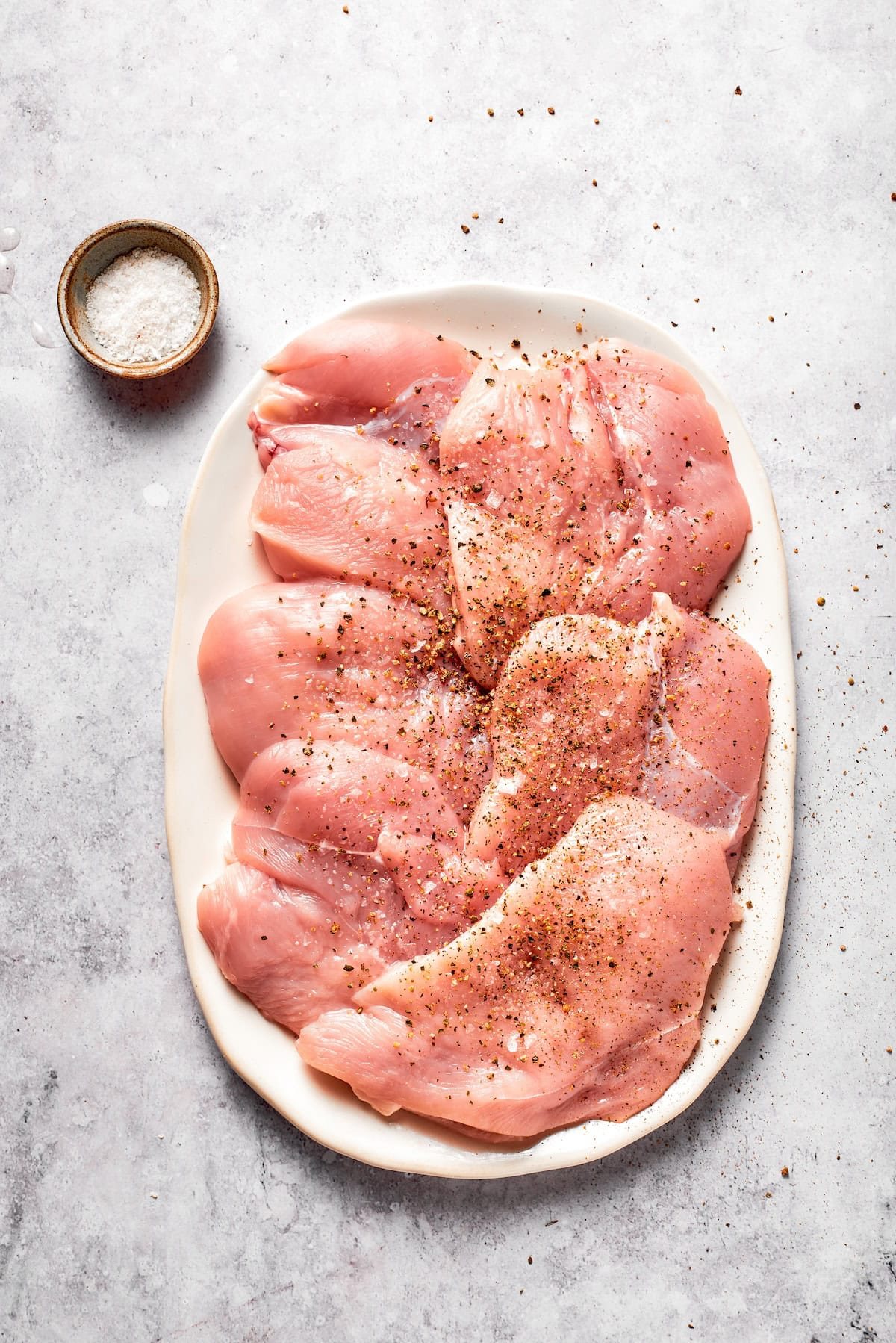 Chicken breasts after being pounded and seasoned.