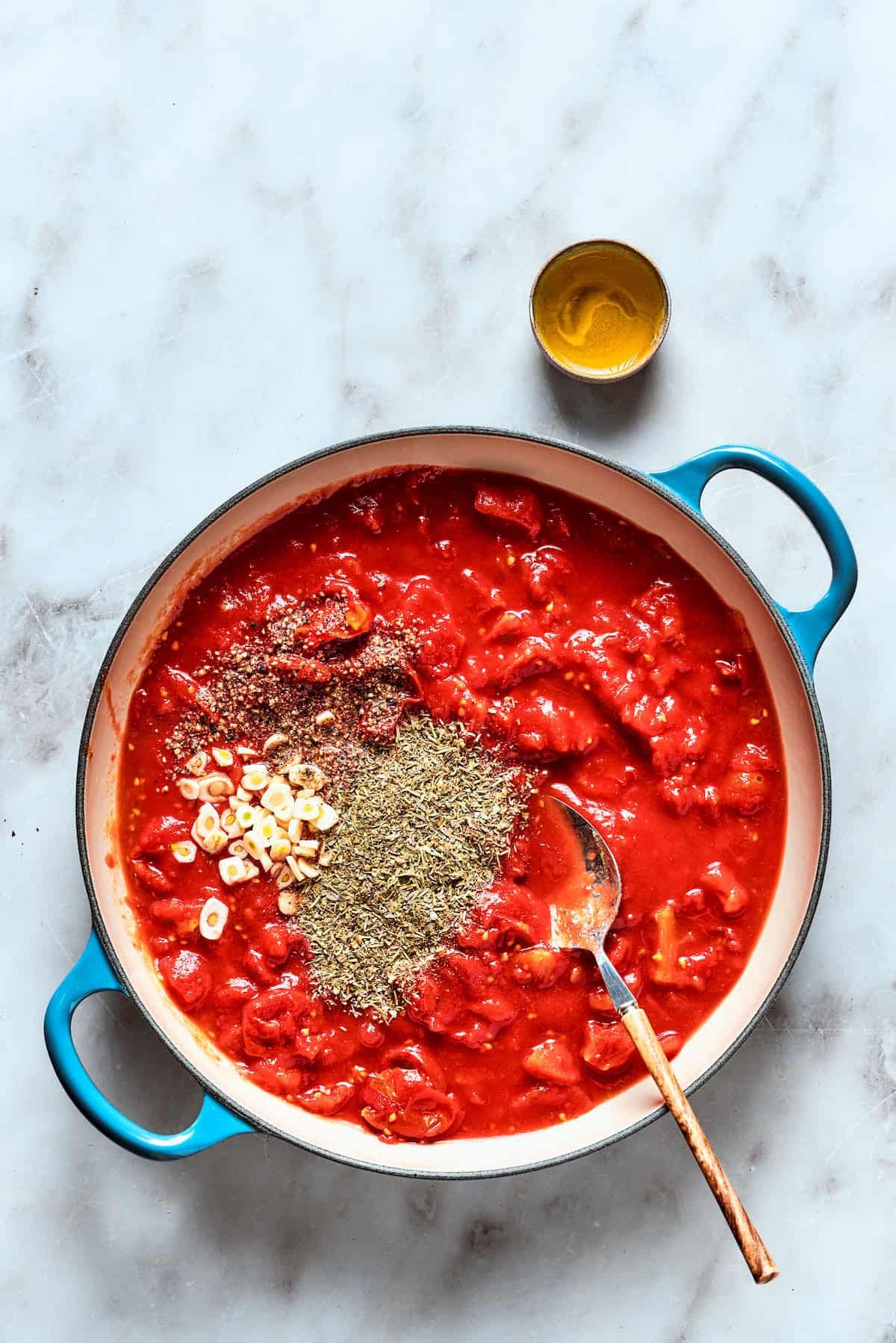 The thick sauce for deep dish pizza is cooked with spices shown on the top.