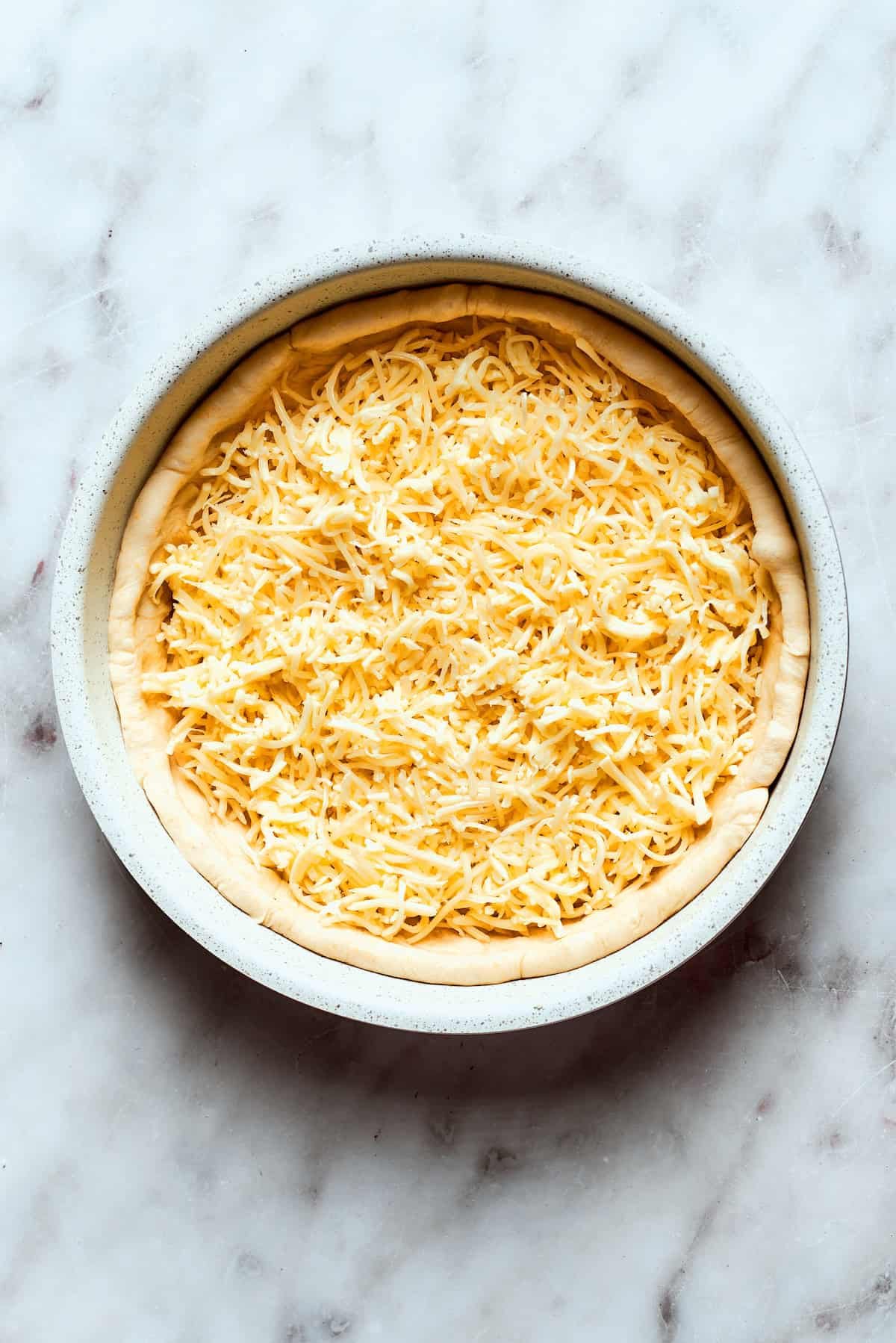 Cheese is added to the pizza.