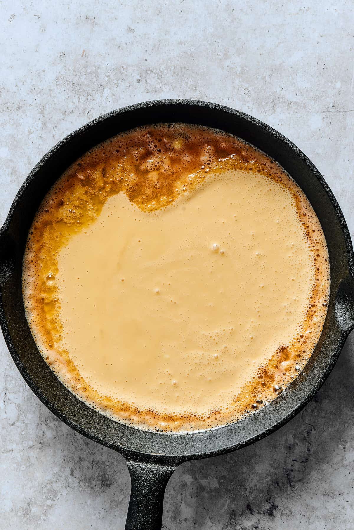 Batter poured into a buttery skillet.