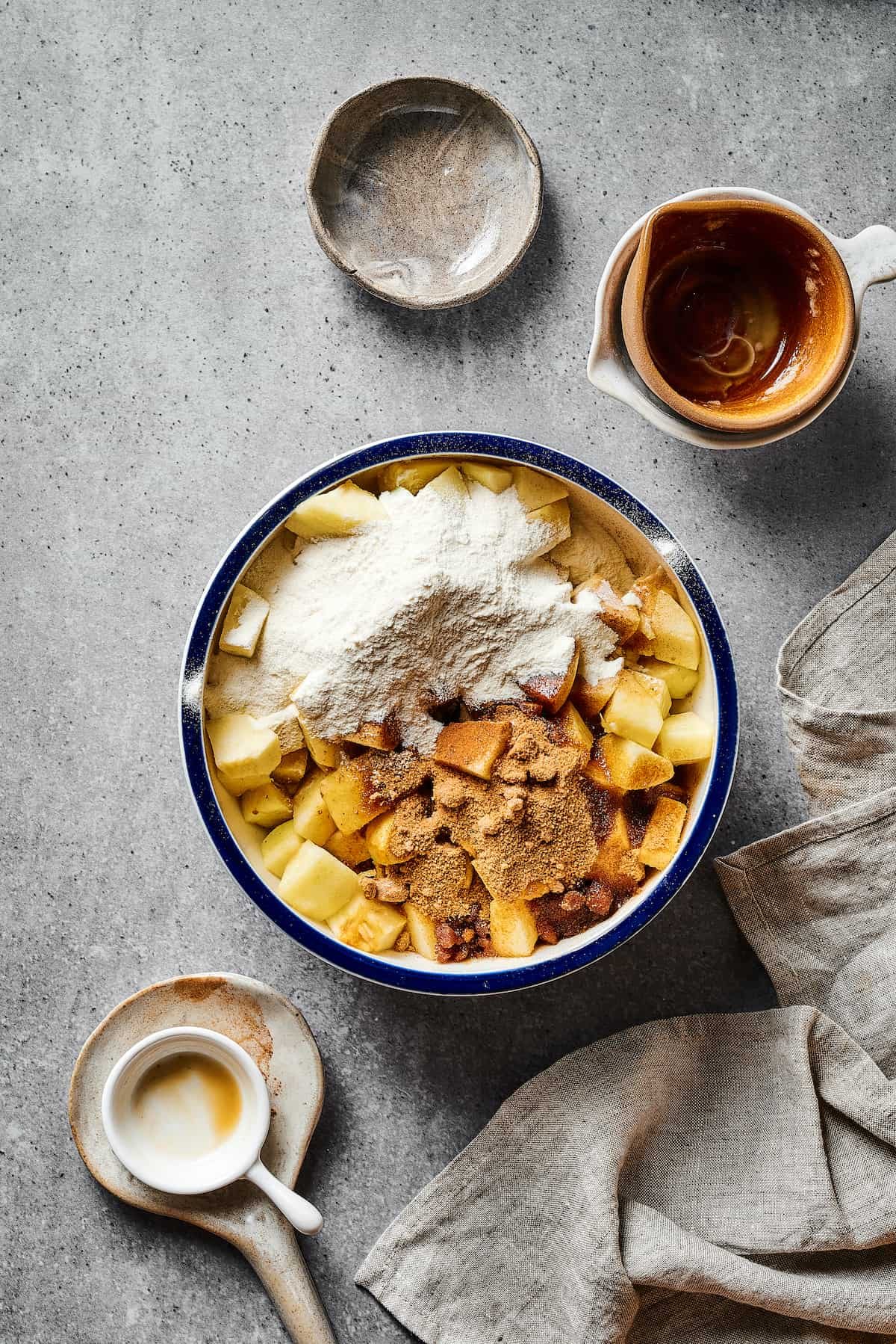 A large bowl of chopped apples with flour, butter, spices, and other ingredients mixed in.
