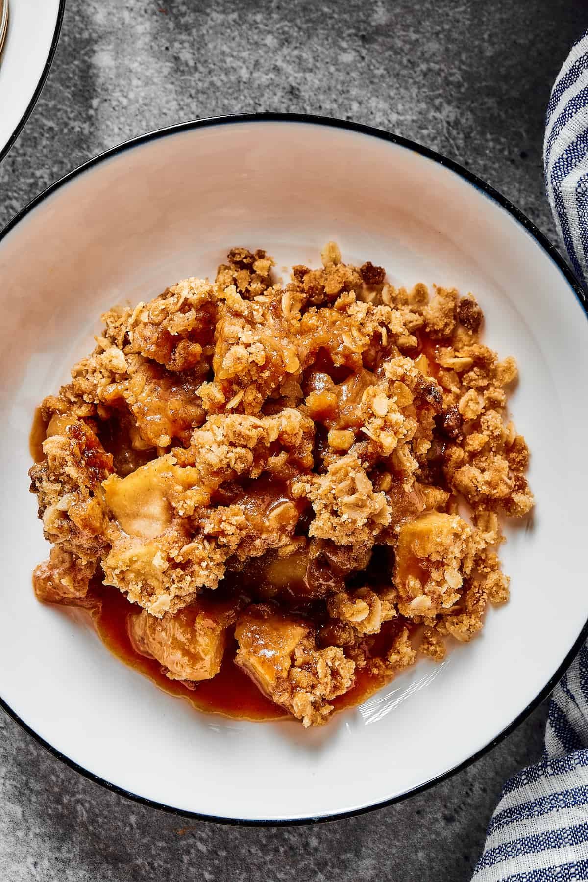 An overhead shot of baked apple dessert with an oat crisp topping.