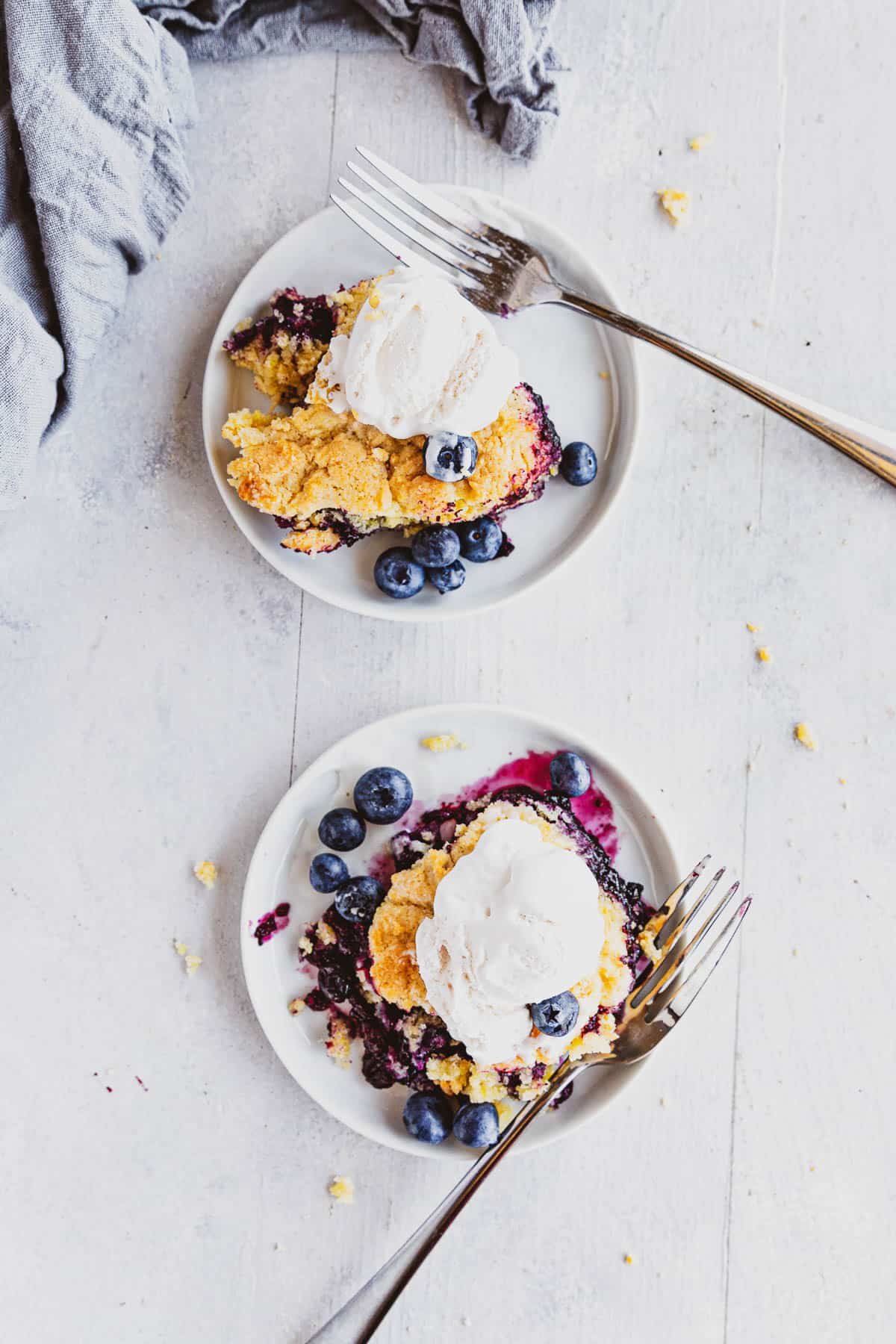 overhead view of two white plates with Blueberry Rhubarb Cobbler