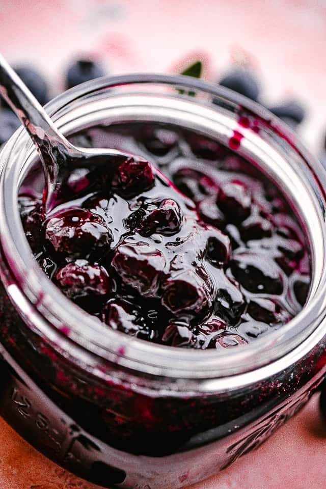 Close up of a jar of homemade blueberry sauce.