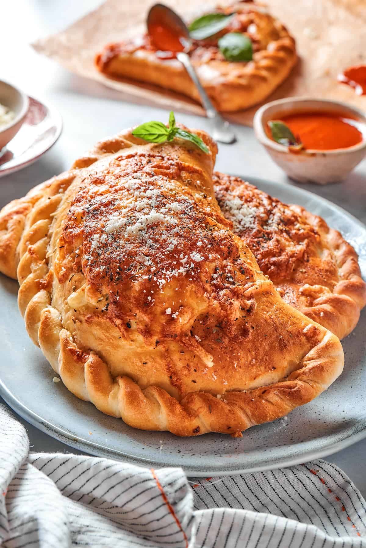 Two baked pizza pockets with crimped edges on a plate.