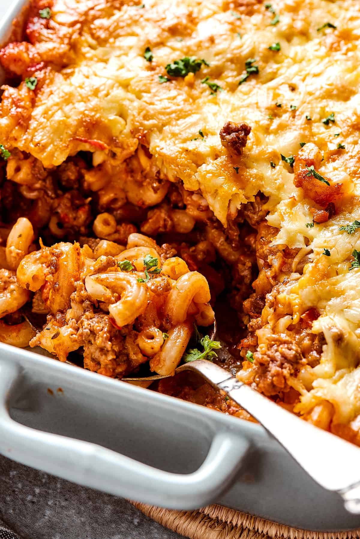 A casserole with a portion scooped out, and a serving spoon resting in the dish.