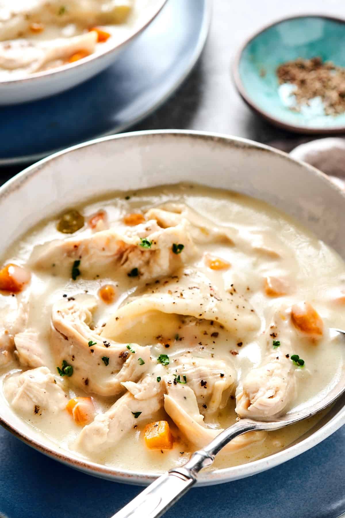 Creamy chicken and dumplings served into bowls.