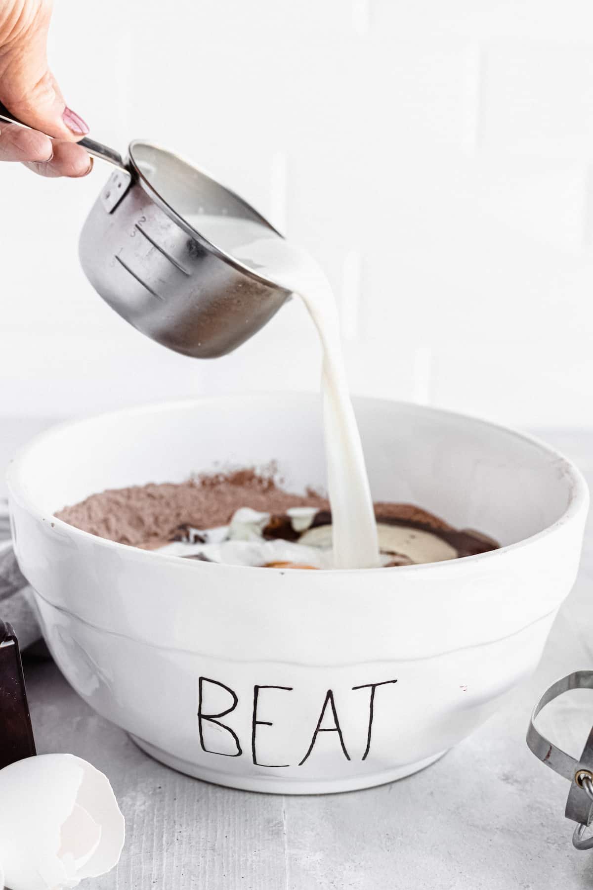 Milk Being Added to the Bowl of Ingredients for Homemade Chocolate Cake
