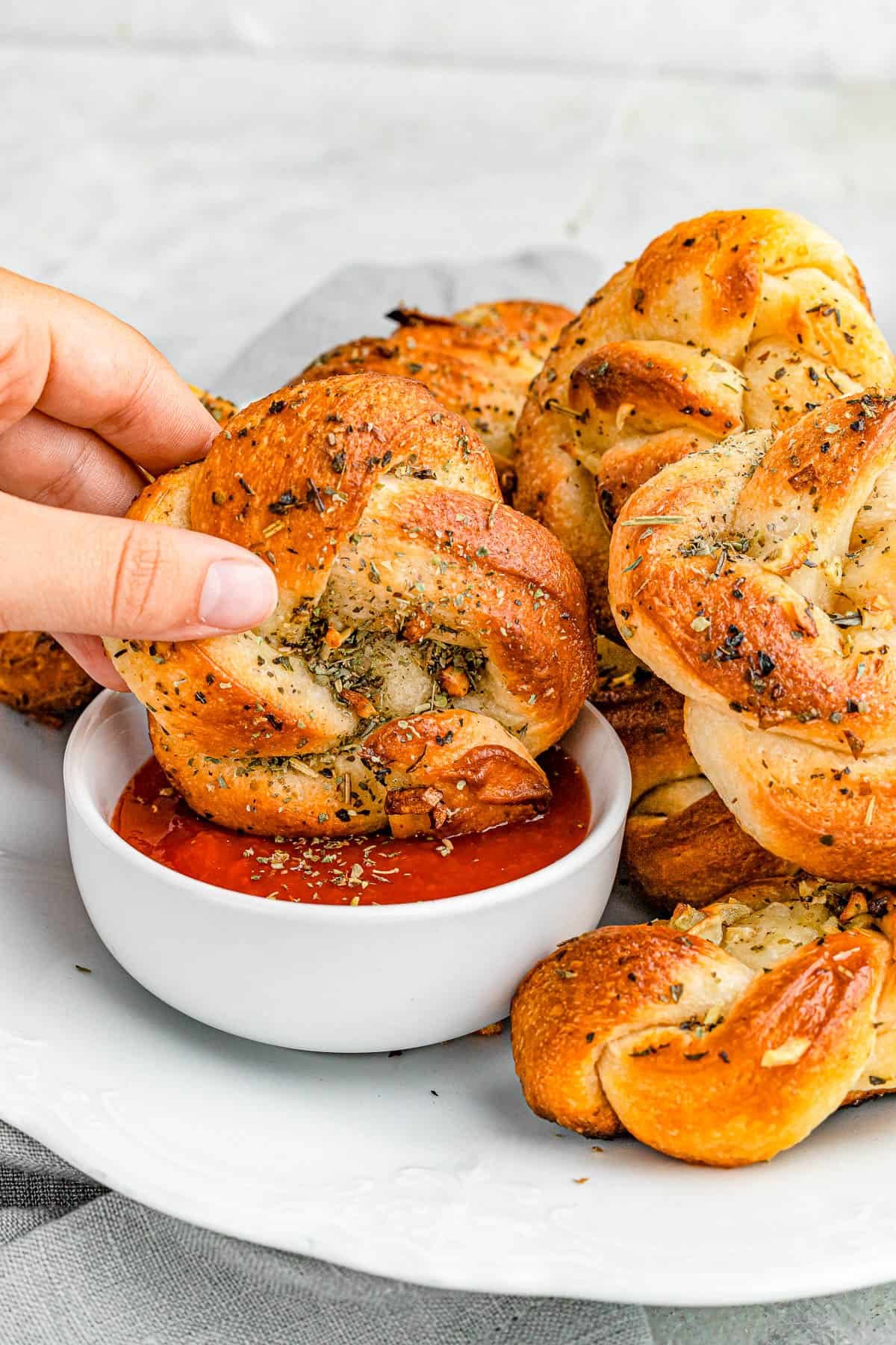 dipping garlic knots in marinara sauce.