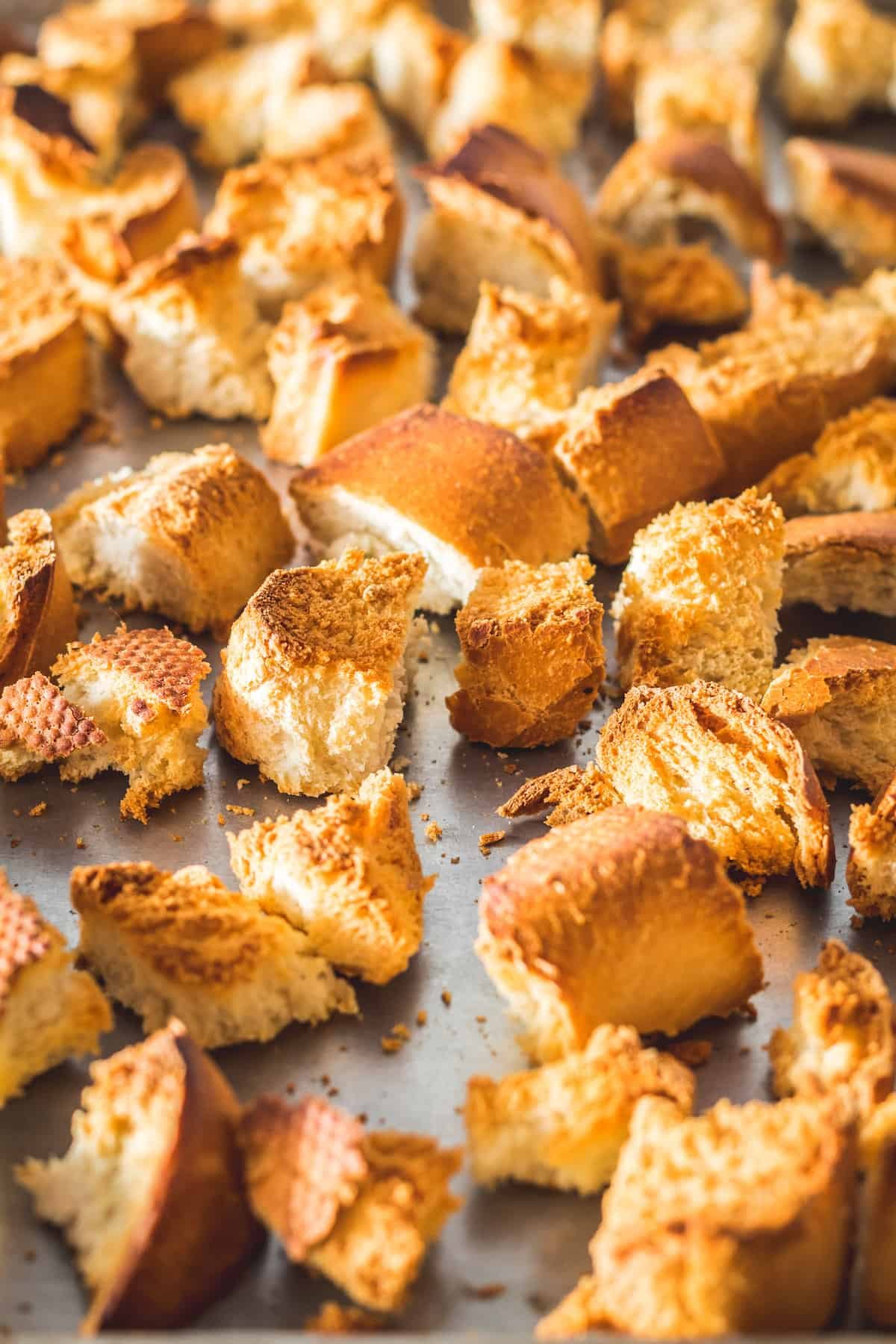 Toasted cubed French bread on a sheet pan.