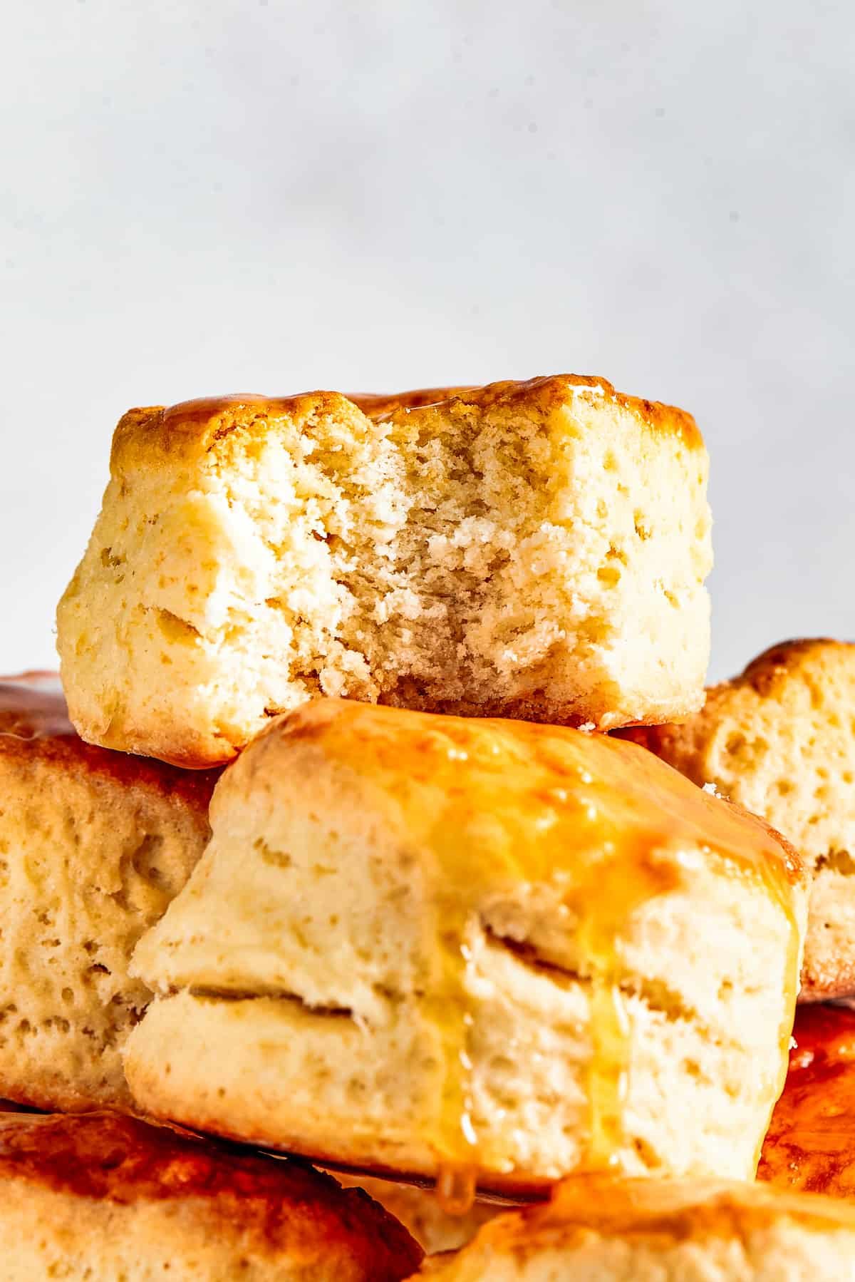 Biscuits piled onto a cake plate. One biscuit has a bite taken out of it.