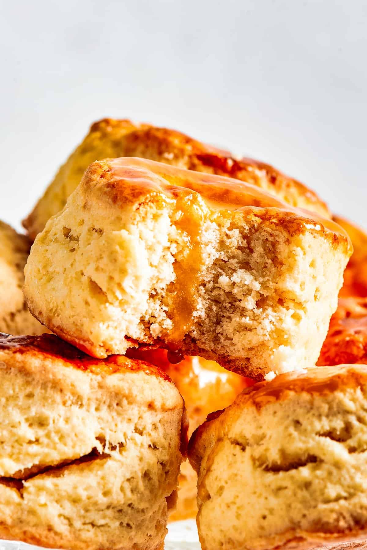 Biscuits piled onto a cake plate. One biscuit has a bite taken out of it.