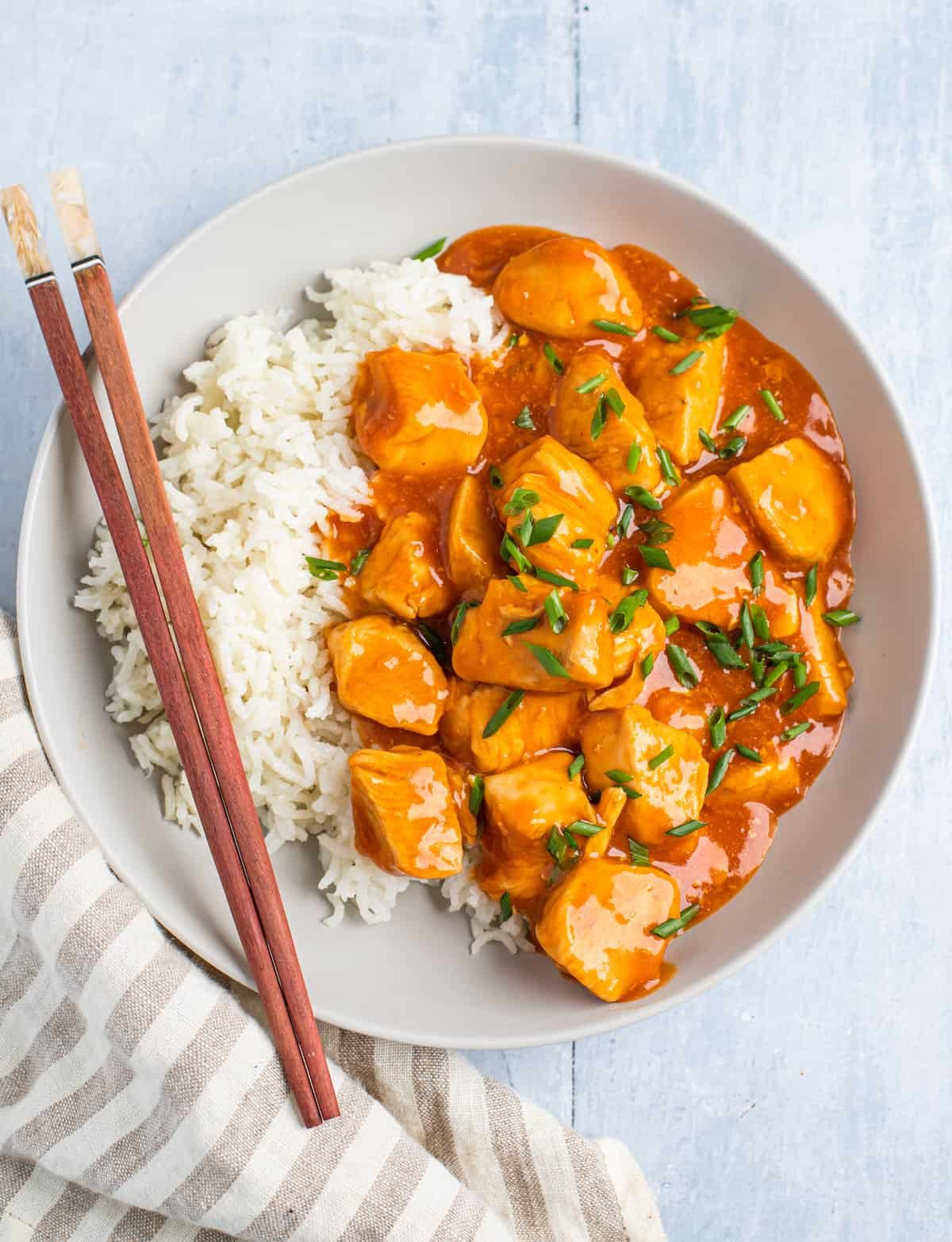 Centered overhead shot of orange chicken with rice.