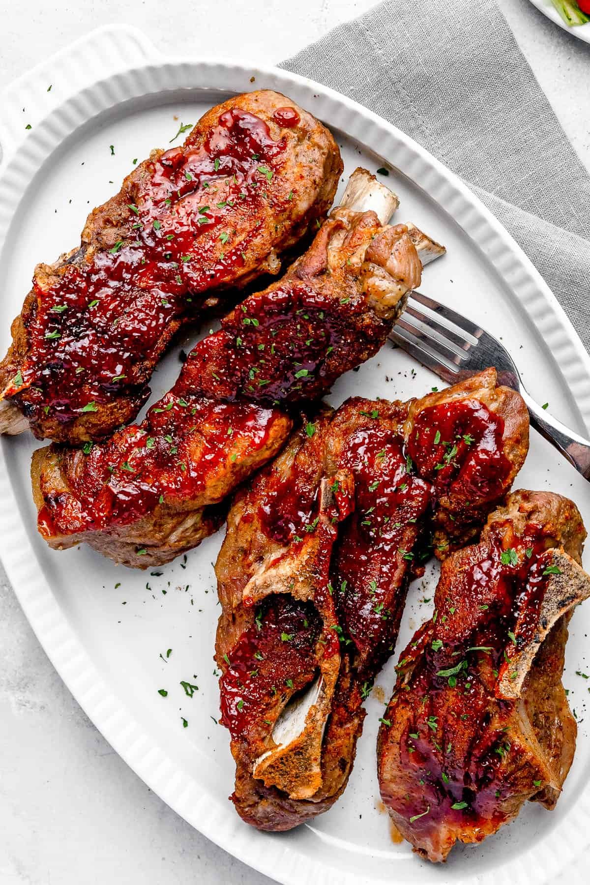 Four Instant Pot Ribs Garnished with Chopped Parsley on a White Plate