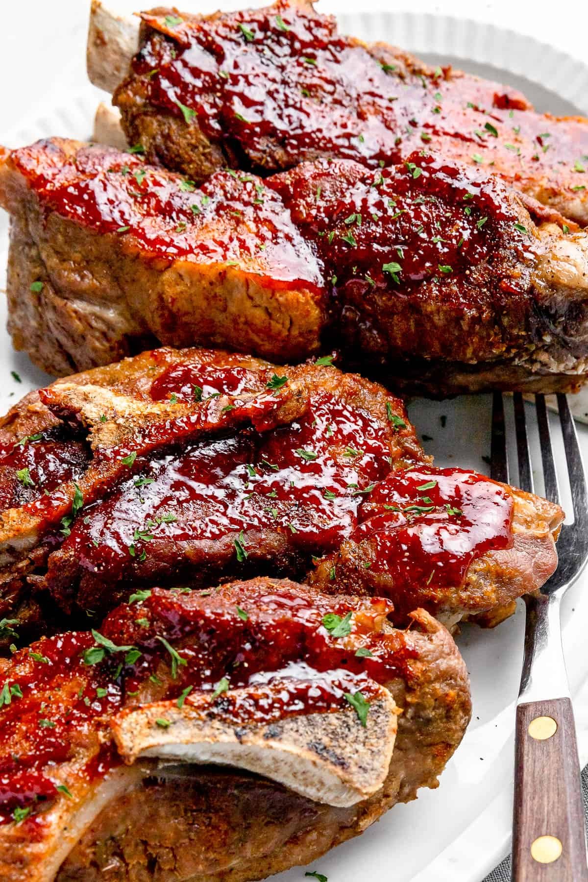 side shot of Instant Pot Ribs on a White Serving Platter with a Small Salad in the Background