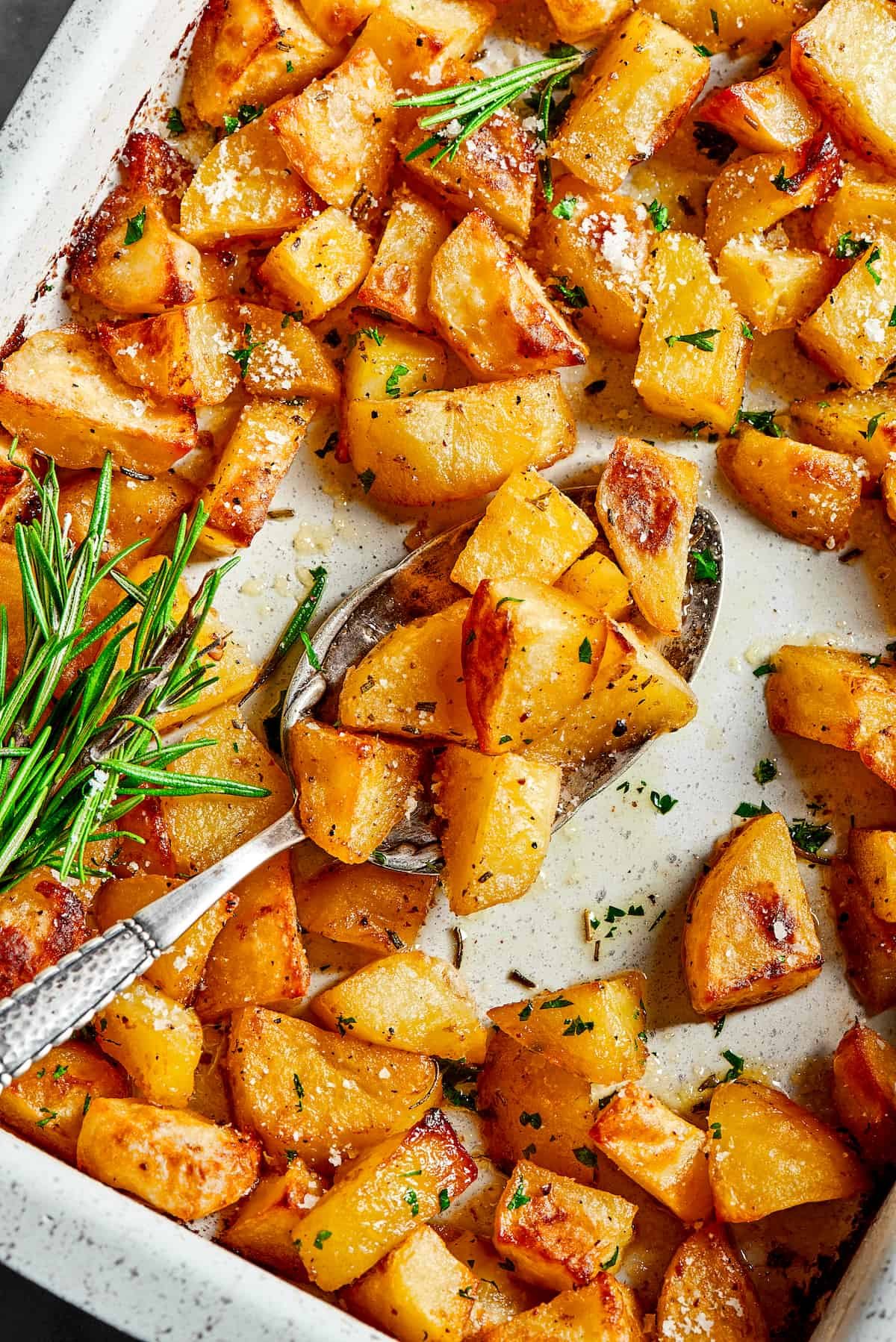 A baking dish with seasoned potatoes inside.