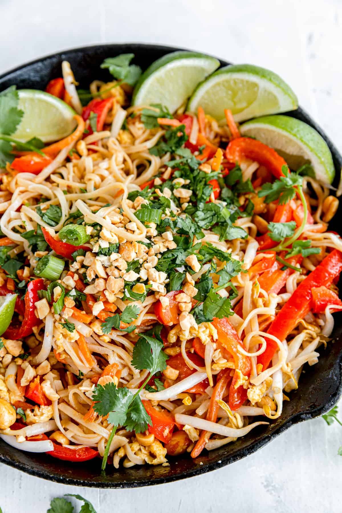 A Black Skillet Filled with Pad Thai on Top of a White Dinner Table