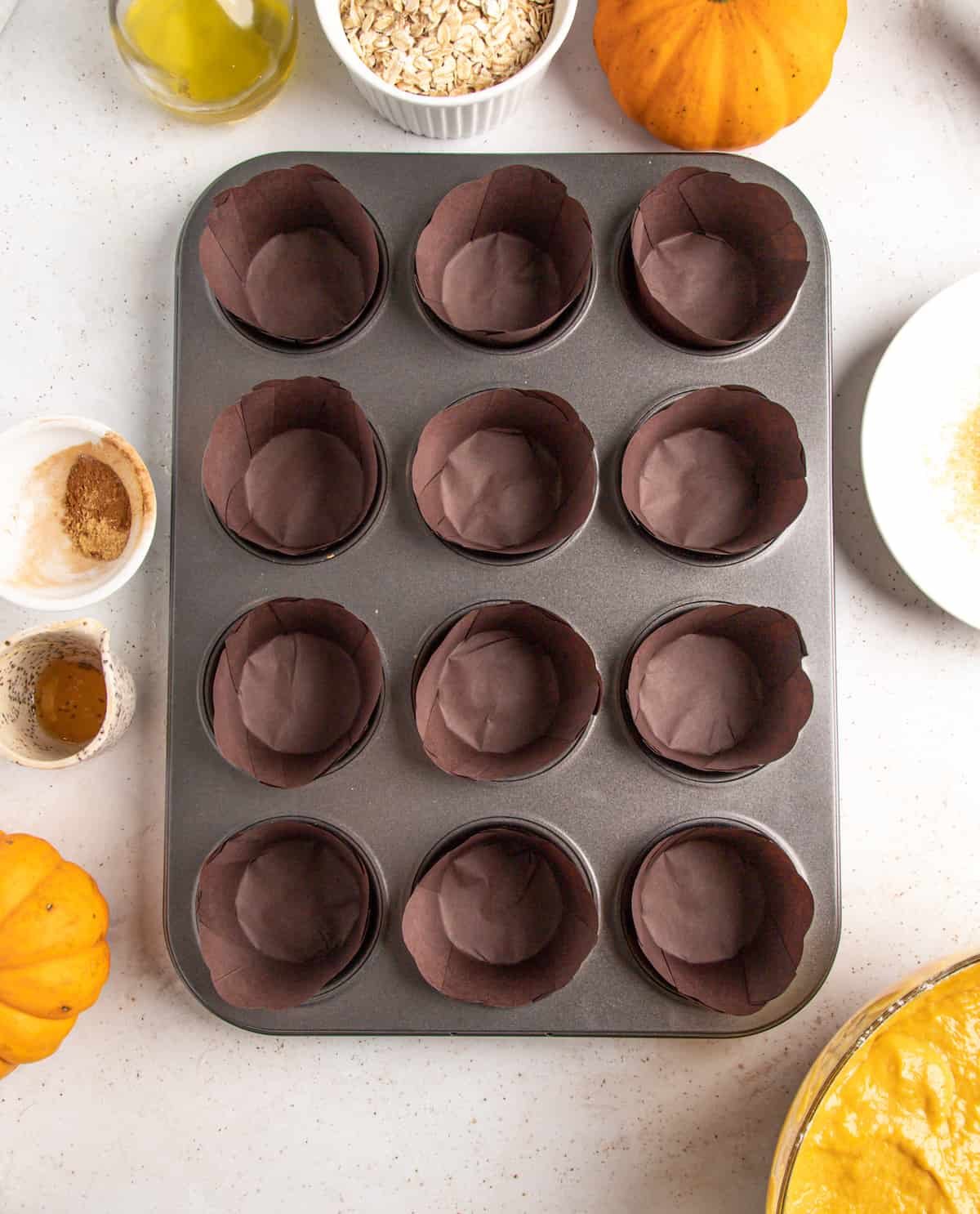 Prepared muffin pan with rustic dark brown paper liners