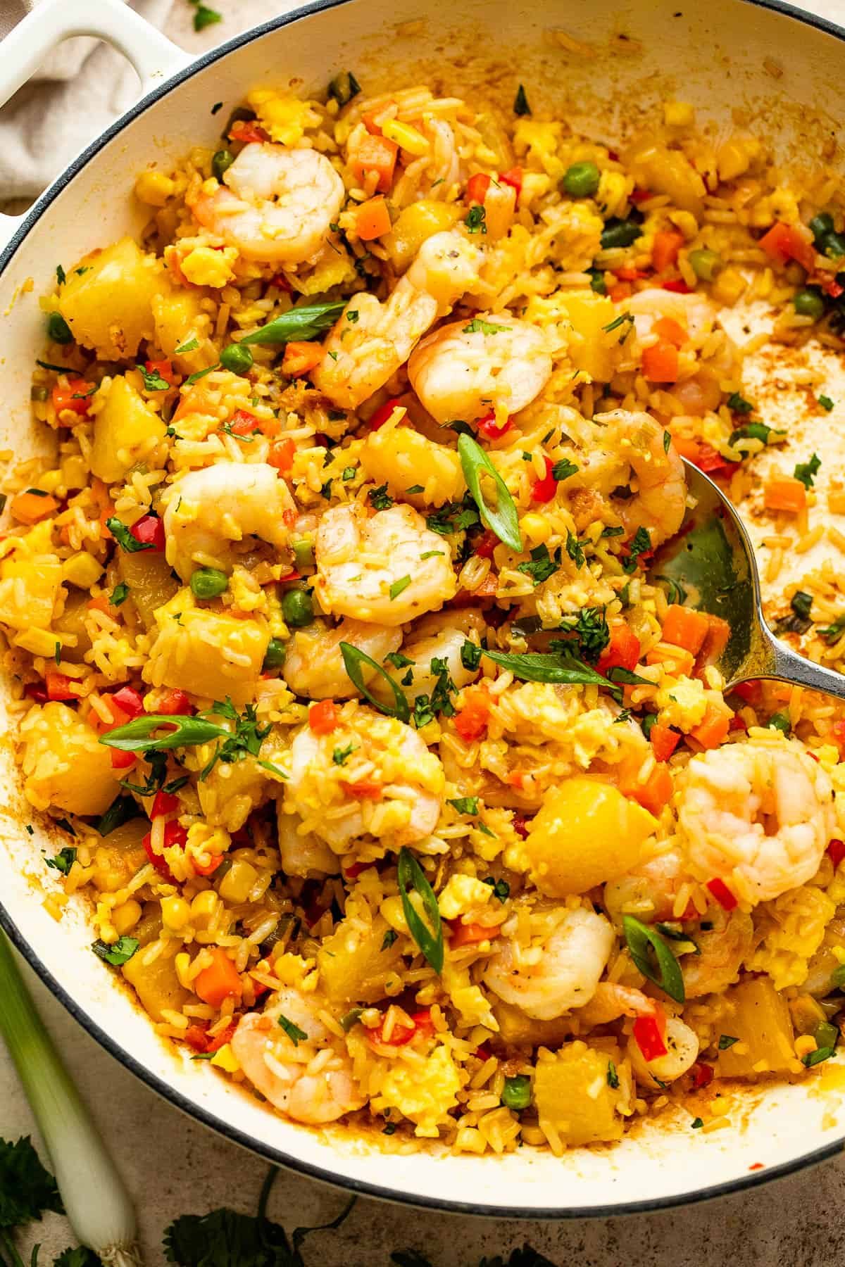 White cast iron skillet with Shrimp Fried Rice and pineapple chunks